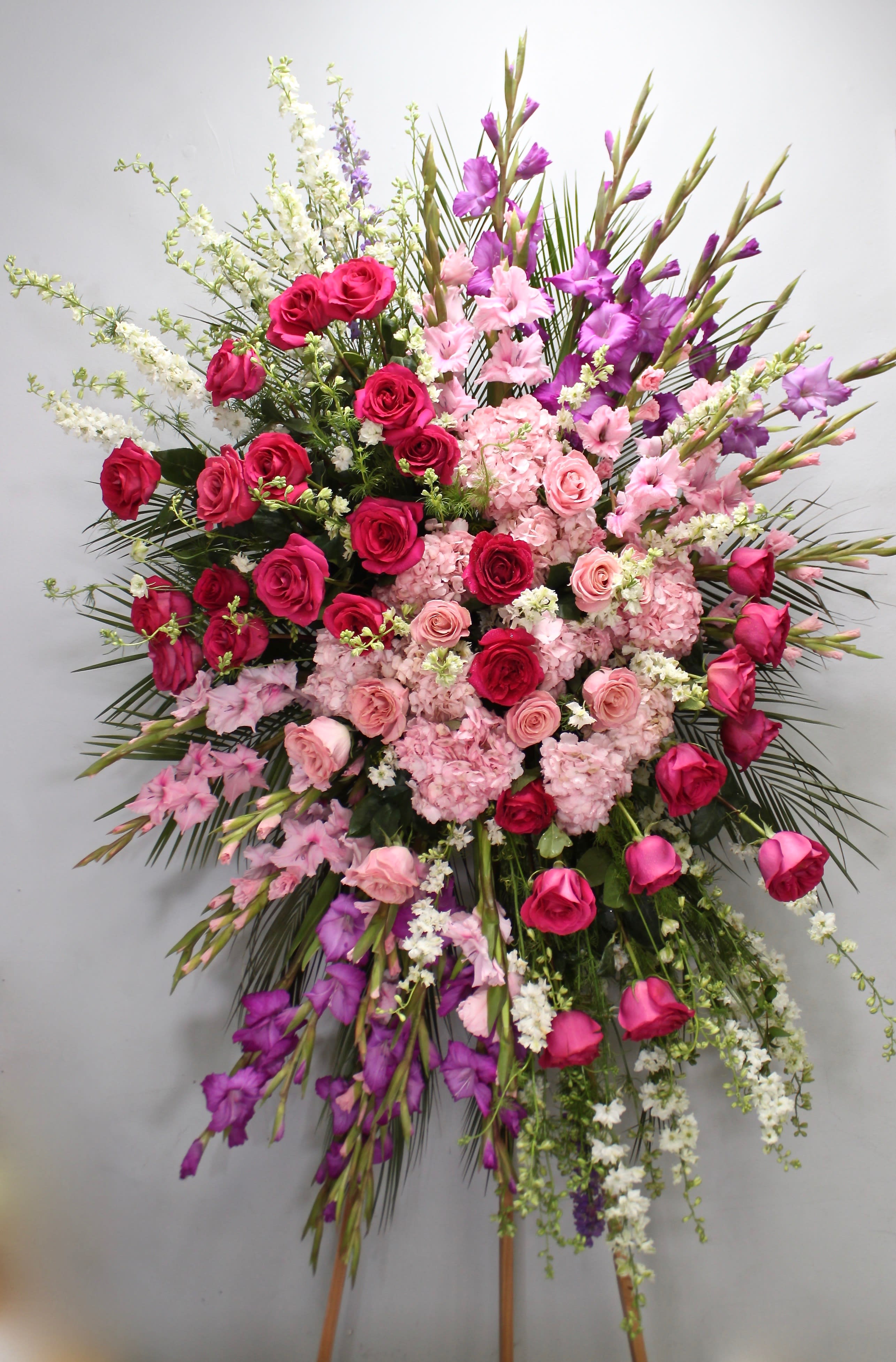 Lady Lovely Spray  - With a bright color palette, this spray includes several shades of pink roses, hydrangeas, and seasonal florals.     We include easel, printed banner and delivery (some fees may apply). An additional banner can be added for $15.    Standard size is 30'' wide, deluxe is 36'', and premium is 42''.
