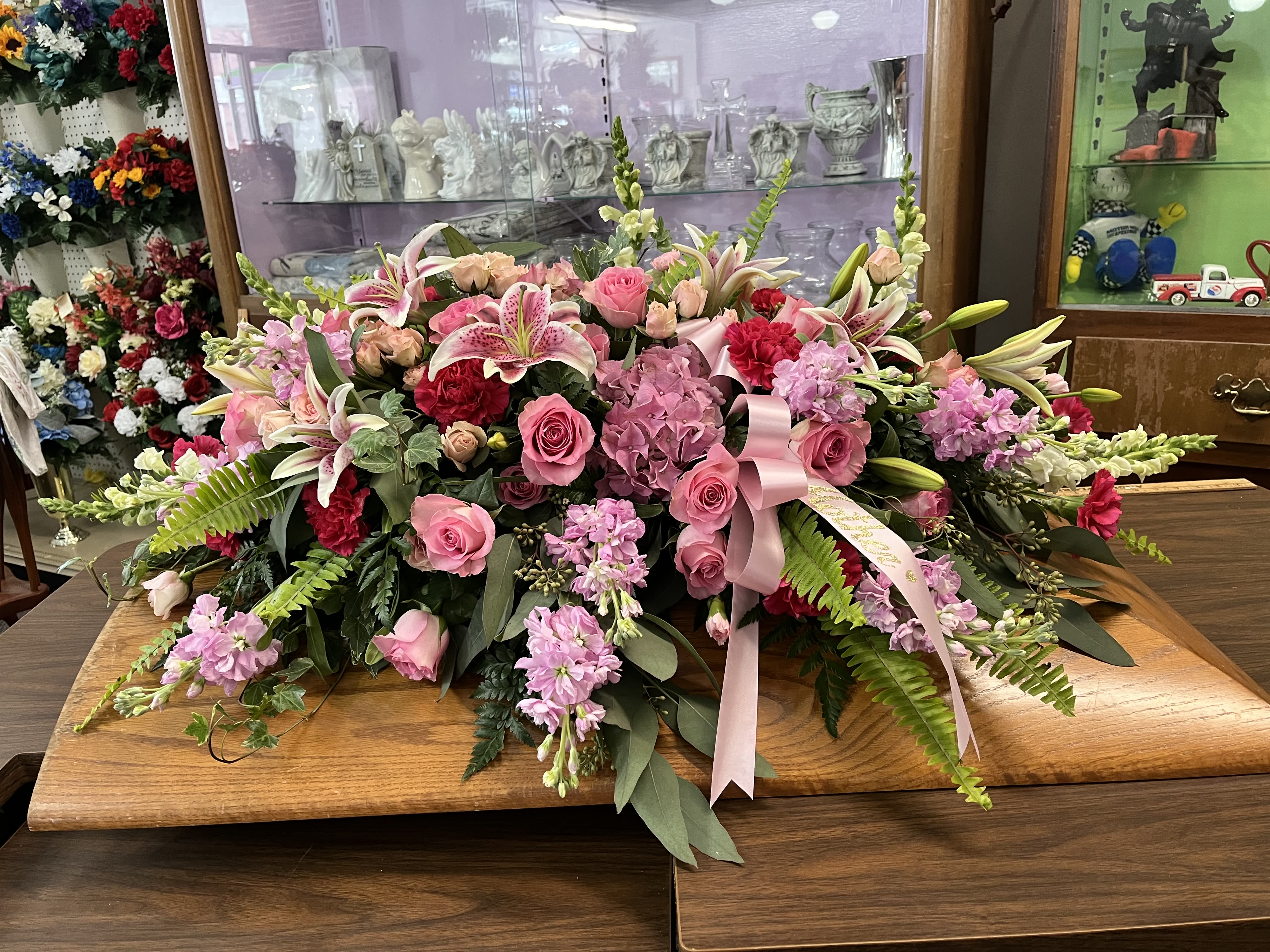 Pink Peace Pink Peace - This is a casket spray that is created with bright pink flowers such as roses, stargazer lilies, hydrangeas, carnations, and stock. Perfect to honor a pink lover's life.