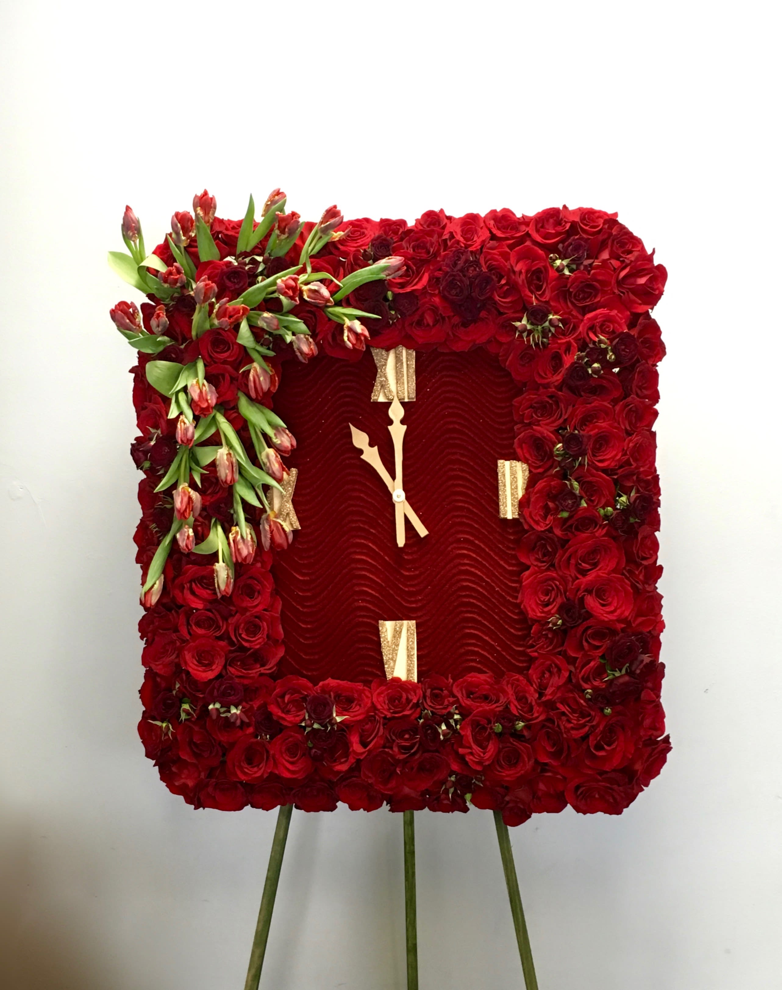 Red Tulips and Roses Frame  - Covered in red roses, this sympathy wreath also contains an accent of tulips in the upper corner. Frames are approximately 32 inches wide. Clock is included.     We include easel, printed banner, and delivery (some fees may apply). An additional banner can be added for $15.