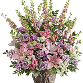 Soft Blush Bouquet - Like a whisper from heaven, the soft pinks and lavenders in this feminine arrangement bring peace and hope in a time of loss. Presented in a large antiqued pot, it's a loving tribute all will appreciate. •This soft pink arrangement features lavender roses, pink spray roses, pink asiatic lilies, lavender carnations, pink larkspur, queen anne's lace, huckleberry, dusty miller, and leatherleaf fern.