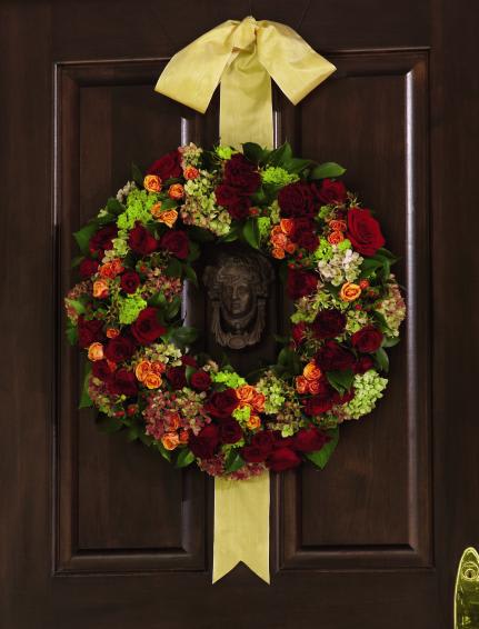 FTD Matrimony Wreath - The FTDÂ® Matrimony Wreath is full of rich, lush color to add to the  dÃ©cor of your wedding day. Red roses, vintage green hydrangea, green  viburnum, orange spray roses, red spray roses, red hypericum berries,  green rose hips and lush greens are brought together to form a stunning  wreath. Hanging from a golden satin ribbon, this arrangement will be the  perfect accent piece for the ceremony or reception. Approx. 22-inches  in diameter. 