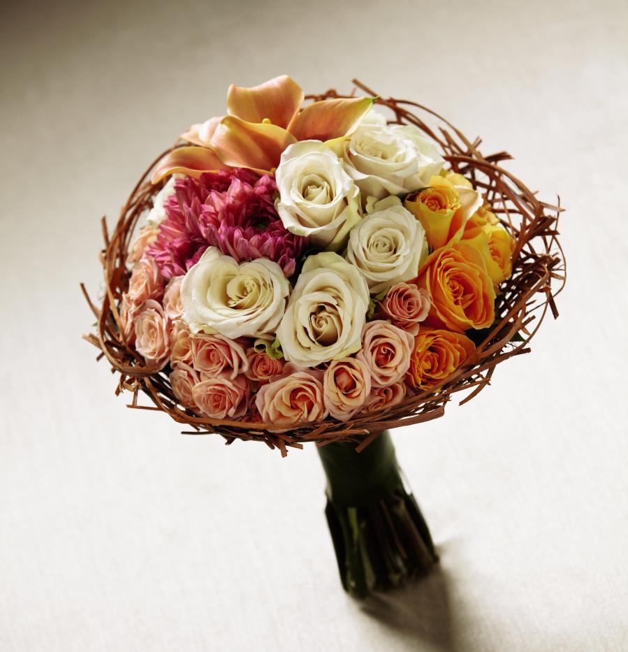 FTD To Have and to Hold Bouquet  - The FTD To Have and To Hold Bouquet blooms with romantic elegance to  set the tone for your wedding day. White roses, orange roses, peach mini  calla lilies, peach spray roses, and dark pink dahlias are arranged in a  tight, compact manner to create a palette of color and texture. Tied at  the stems with fresh tropical leaves and accented around the bouquet  with a wired raffia bouquet collar, this arrangement is both lovely and  memorable. Approx. 12-inches in diameter.  