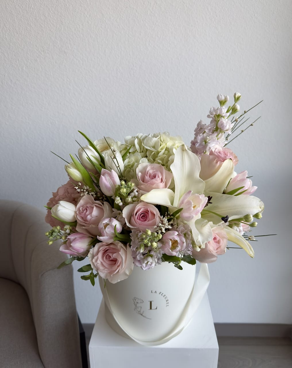 Spring Glow - This romantic arrangement includes roses, spray roses, tulips, lilies and greens.  Perfect for any occasion. You can choose any color of the box.  Arrangement includes:  SMALL BOX Custom greeting card 