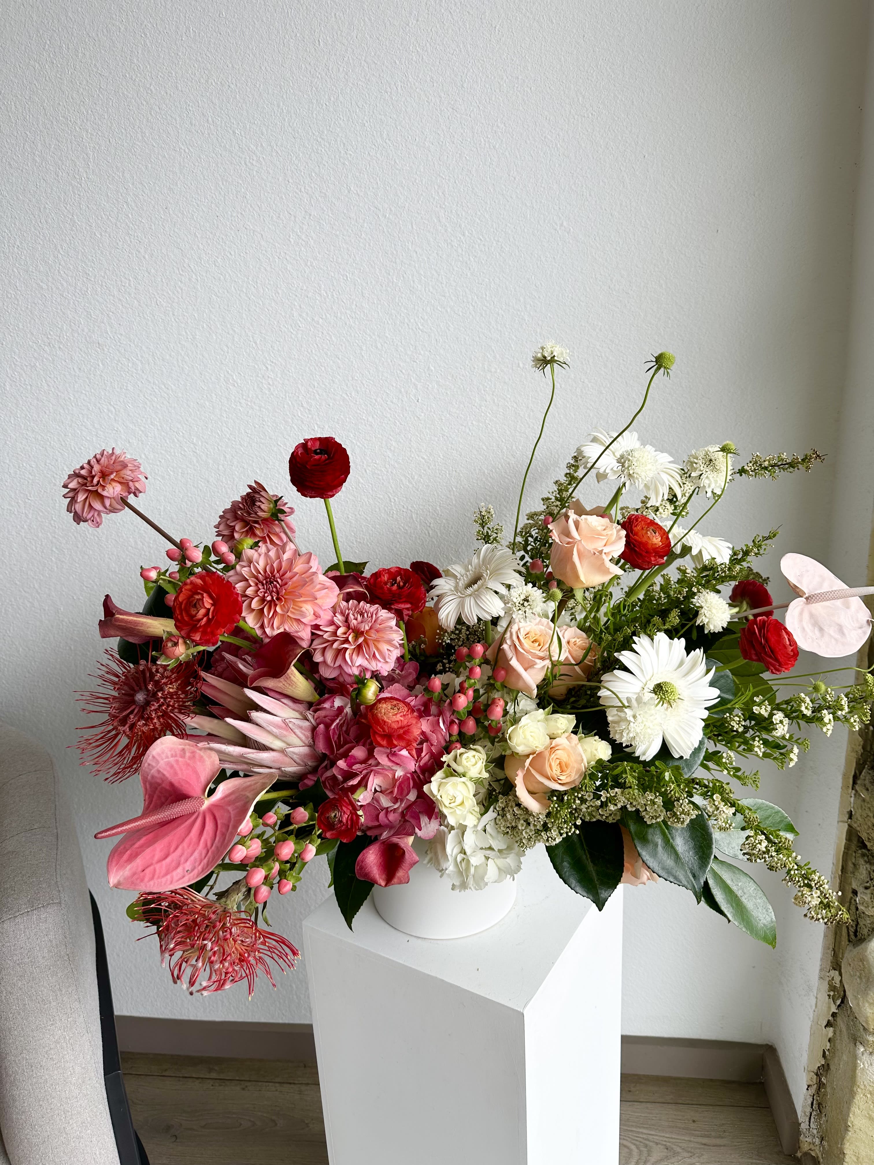 Vibrant Harmony - This beautiful arrangement is filled with red and peach roses, hydrangeas, dahlias and greens to deliver your special message to your special someone.  Perfect for any occasion.  Arrangement includes:  White Vase Custom greeting card