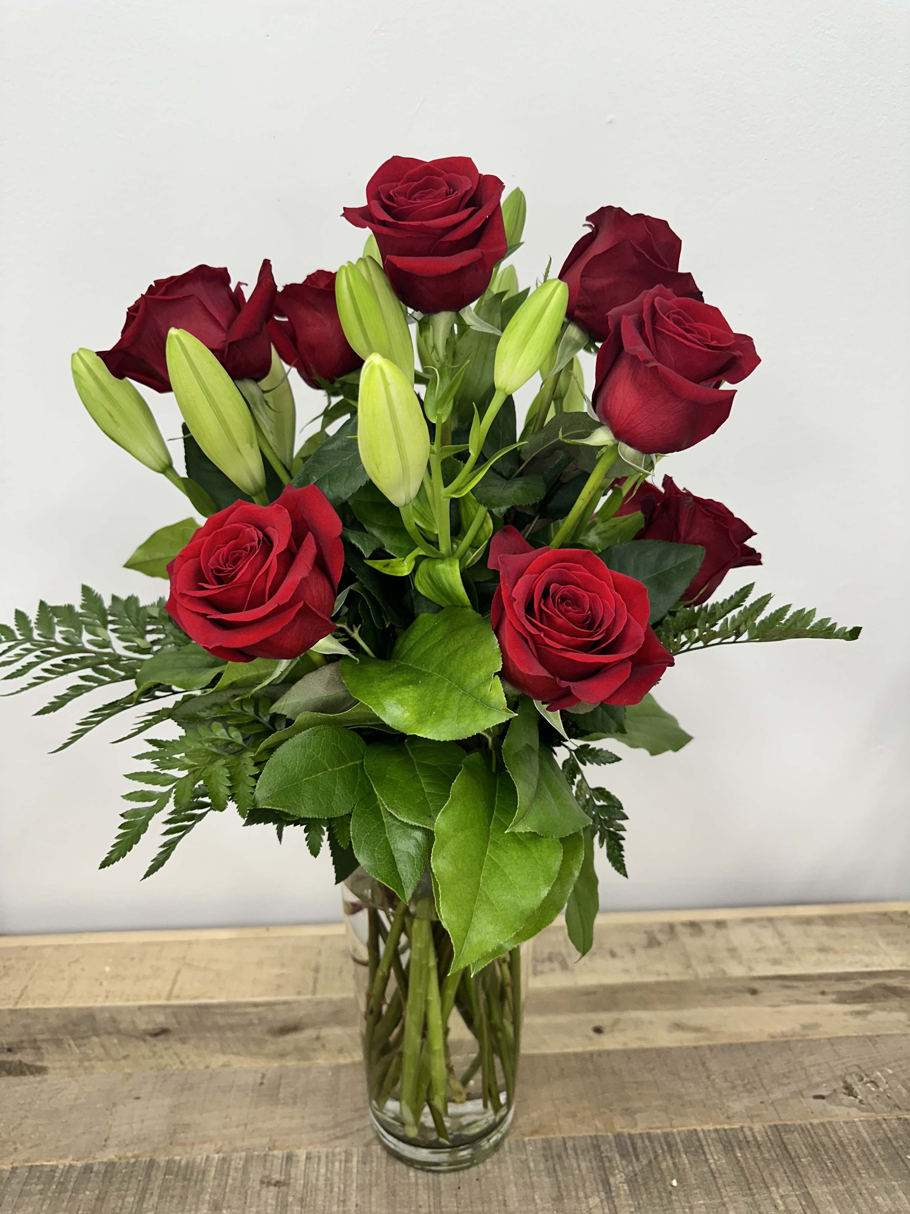 Tower of Rose Richness -  Introducing the &quot;Tower of Rose Richness&quot;! This stunning arrangement features a dozen luxurious roses, complemented by elegant lilies and lush greenery, all gracefully displayed in a tall vase. 