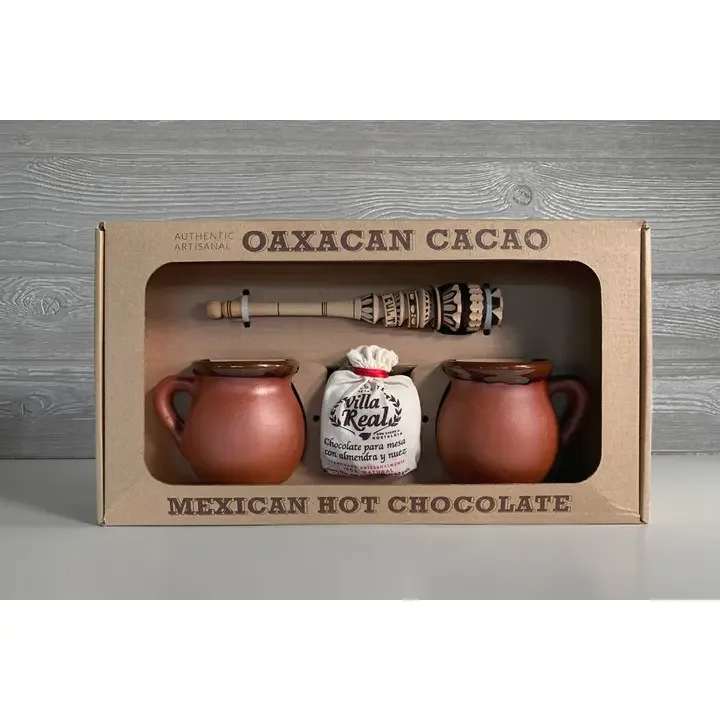 Mexican Hot Chocolate Gift Set - Smal - To make authentic Mexican Hot Chocolate, you need traditionally made chocolate, a hand-carved molinillo, and the perfect ceramic mug to drink it out of. Luckily, we've put together this Mexican Hot Chocolate gift set with everything your customers will need for the perfect gift. Cocoa is a key part of the Mexican gastronomy - it’s a legacy food made for sharing. By using everything in our Mexican Hot Chocolate Gift Set, your shoppers will get rich, complex-flavored, smooth hot chocolate drink that will retain the unique aroma and nostalgic taste enjoyed for generations.  What's included:   Villa Real Mexican Hot Chocolate with Almonds: Set of 2 Clay Mugs Small Traditional Molinillo Whisk  *Lead Free  Size of gift box: 16 x 9 x 4''