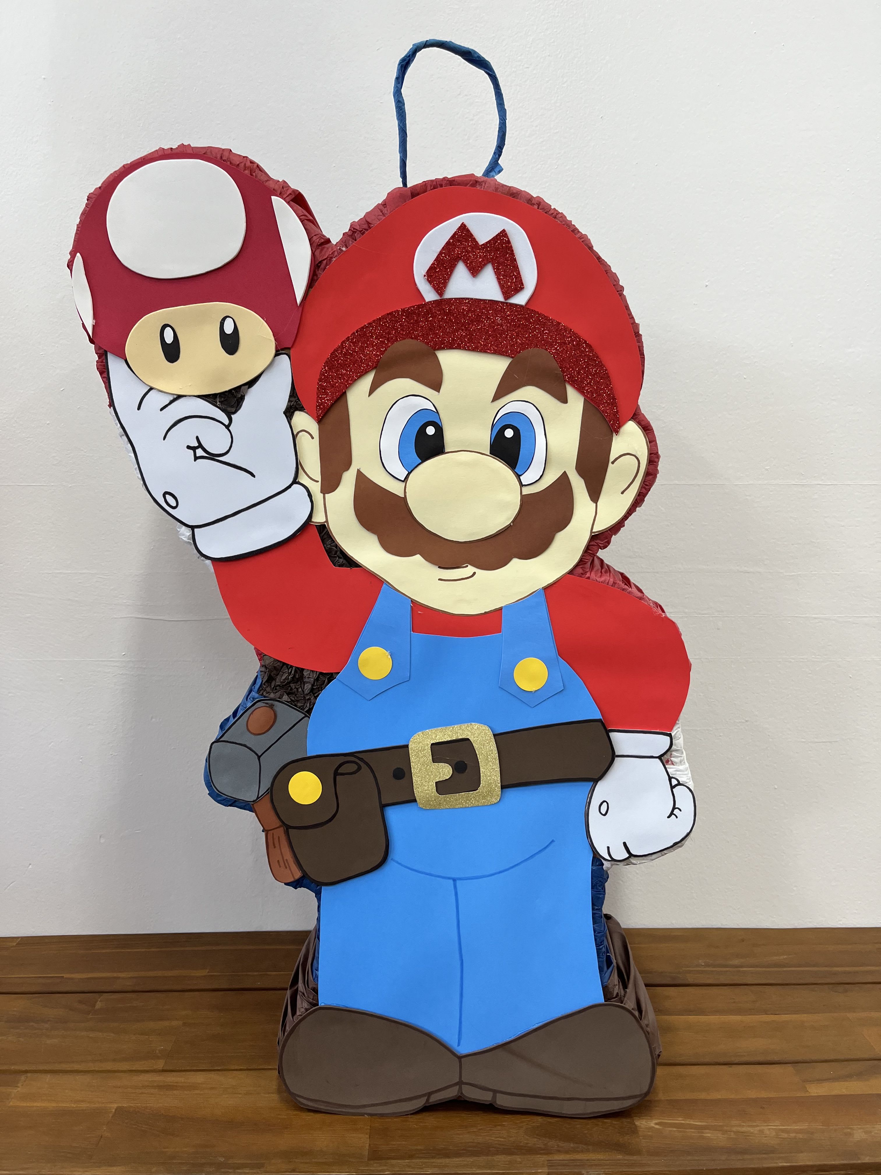 Super Mario Piñata - Bring the excitement of the Mushroom Kingdom to your party with our Super Mario Mushroom Adventure Piñata! Dressed in his iconic red hat and blue overalls, Super Mario is ready for action, holding a classic green mushroom. This vibrant piñata is perfect for adding a touch of fun and nostalgia to your celebration, making it ideal for fans of the beloved video game series. Whether it’s a birthday party or a gaming-themed event, this piñata will delight guests of all ages and make your celebration truly memorable.