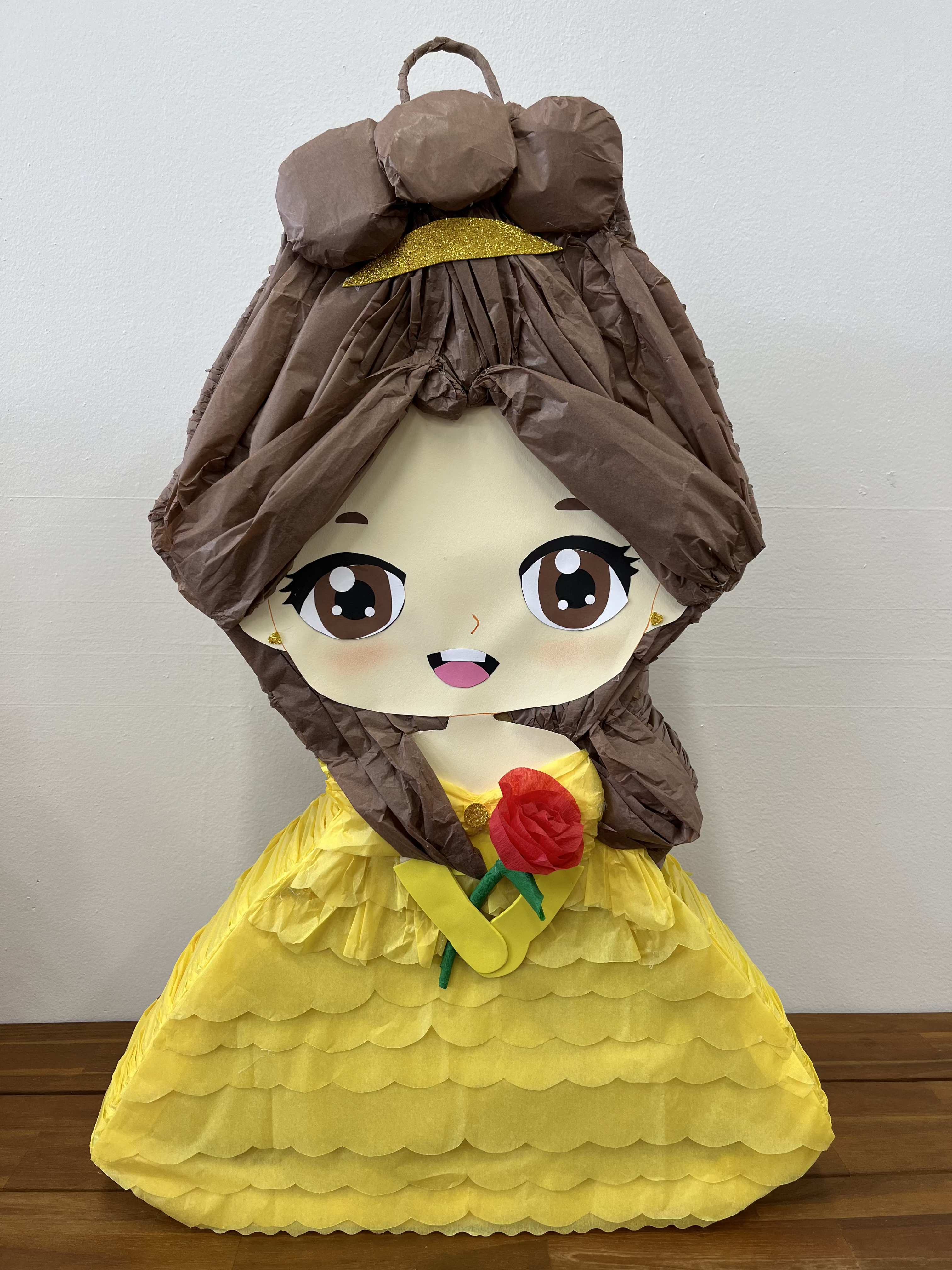 Yellow Princess Piñata Yellow Princess Piñata - Bring a touch of royal charm to your celebration with our enchanting Princess in Yellow Piñata. Dressed in a beautiful yellow gown and holding a vibrant red rose, this piñata is sure to be the centerpiece of any party