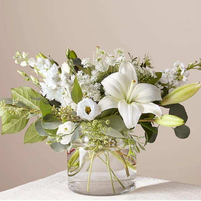 Alluring Elegance Bouquet - An illuminating array of florals brings an air of elegance to any room it's placed. This arrangement features refined florals like lilies, Queen Anne's Lace and Veronica in a clear glass vase to add a touch of sophisticated style to your special occasions.  Please Note: The bouquet pictured reflects our original design for this product. While we always try to follow the color palette, we may replace stems to deliver the freshest bouquet possible, and we may sometimes need to use a different vase. DETAILS 20&quot;h x 19&quot;w BLOOM DETAILS Eucalyptus Lily Queen Anne's Lace Stock Veronica