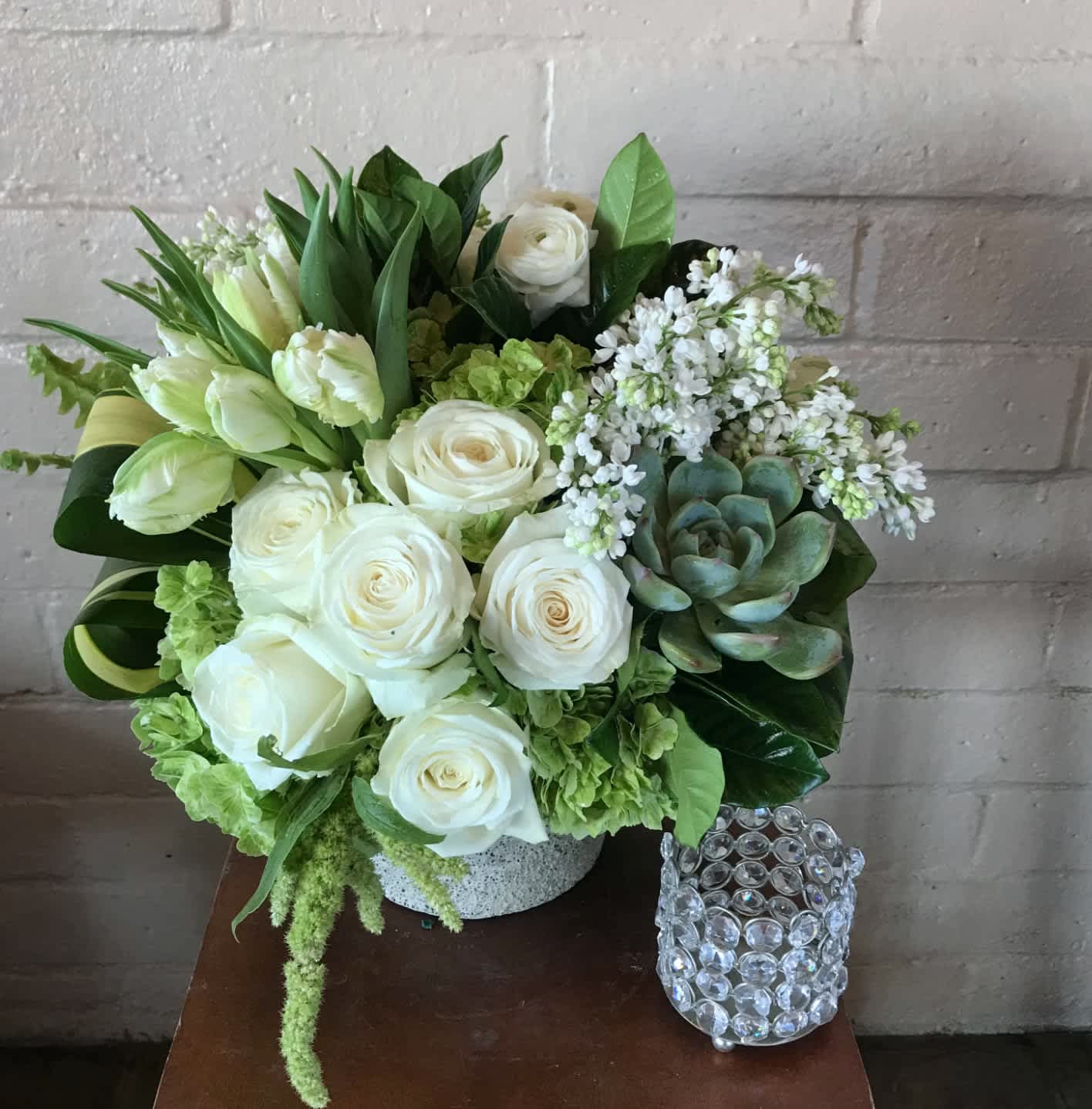 Beautifully Organic - This stunning green and white arrangement including tulips, white lilac, hydrangea, a succulent, and roses is the perfect gift to freshen up someone’s home, offer comfort and peace in a time of sympathy, or share the natural organic beauty of flowers with a friend or loved one. Please keep in mind some of the flowers here are seasonal such as white lilac and ranunculus. If they are unavailable upon ordering we will be sure to replace with something equally beautiful and of value.