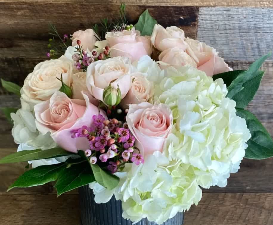Love  - A sweet, romantic mix of soft blush pink roses and garden spray roses nestled in a bed of white hydrangea. 