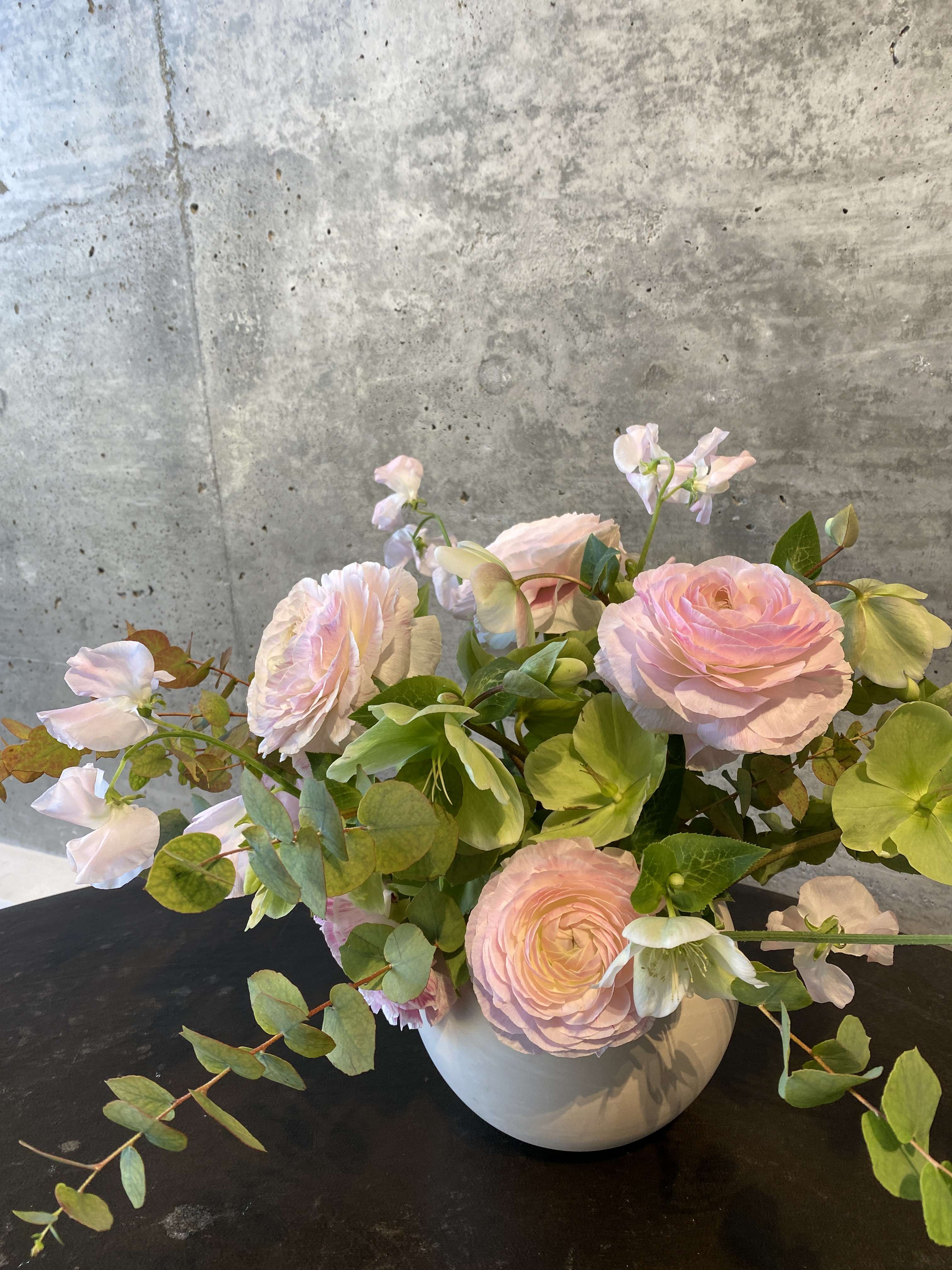 Hampton - A loose, free flowing arrangement crafted with ranunculus, sweet pea, hellebore, and rose. 