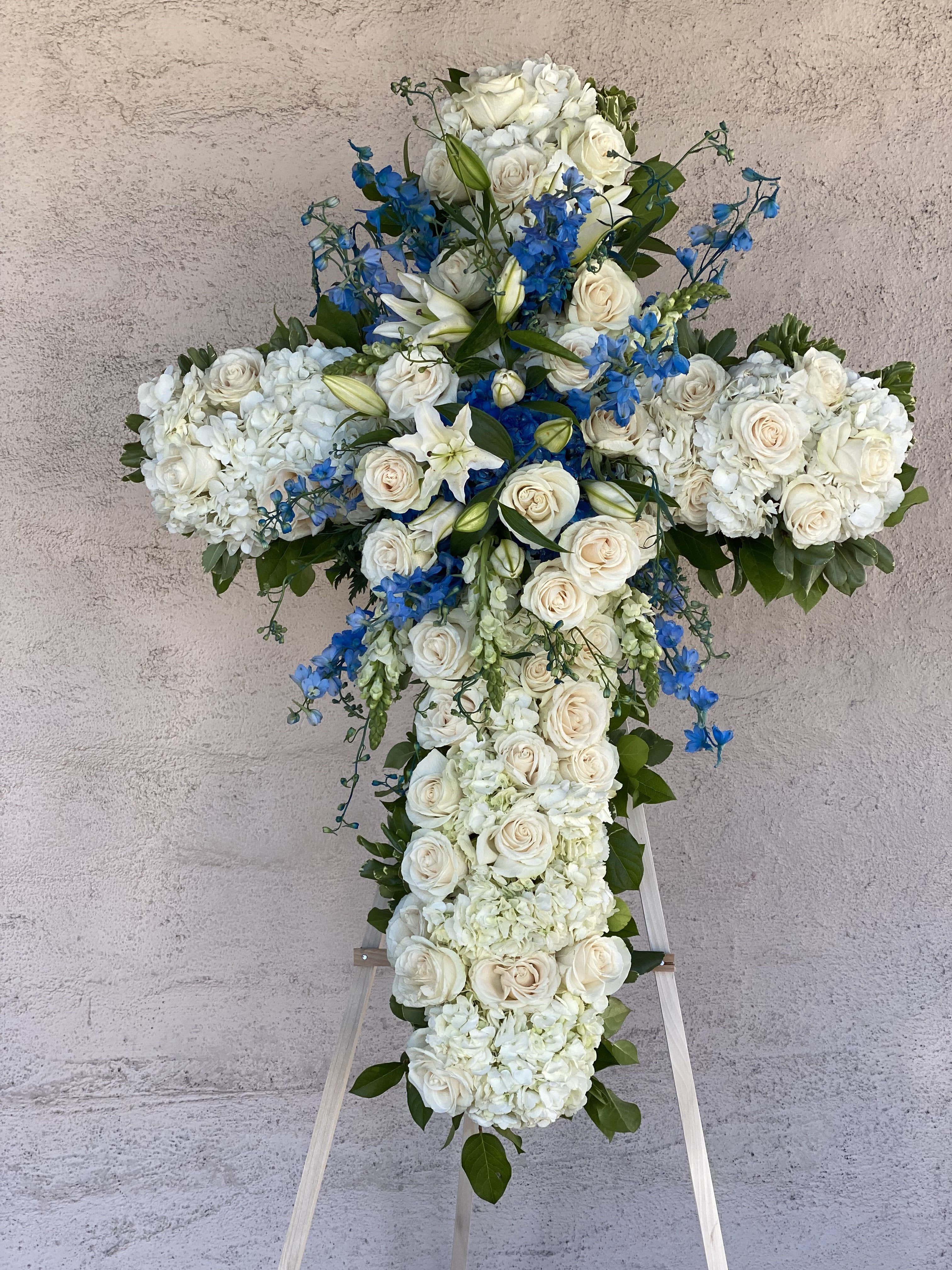 Heavens Above Sympathy Cross - Sympathy cross arranged with hydrengeas, blue delphiniums and cream color roses.  