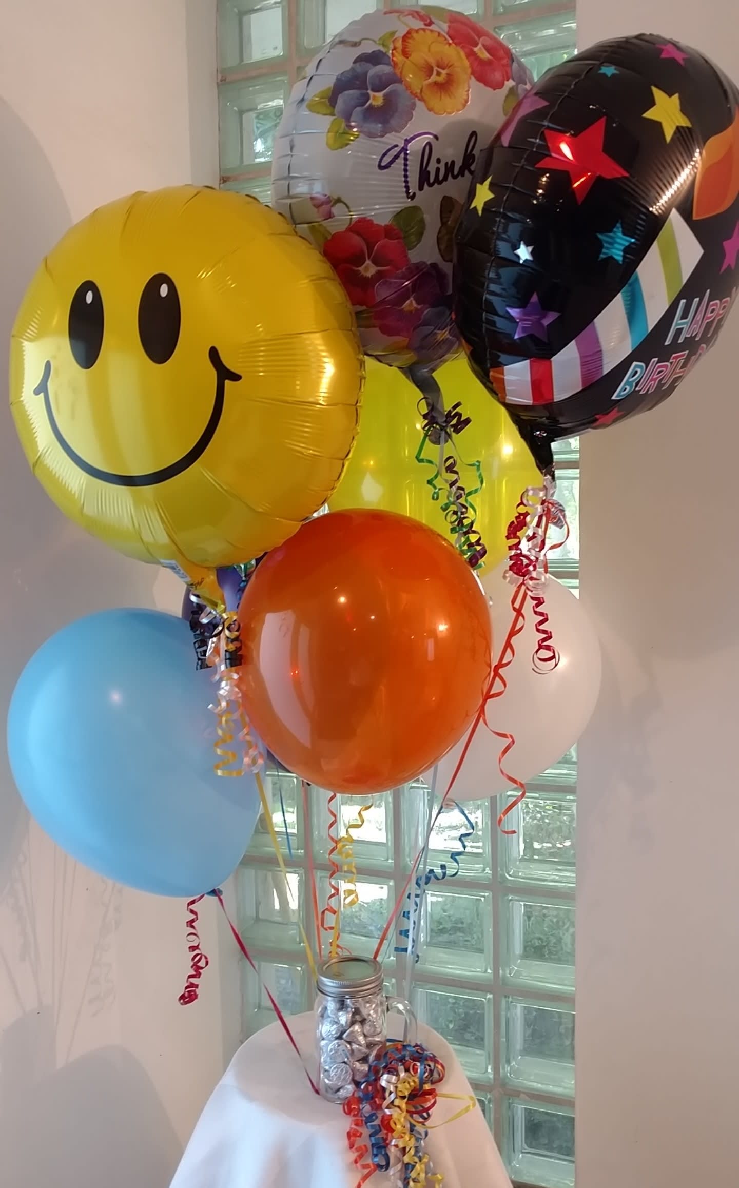Balloon Bouquet - A light and whimsical gift any occasion: get well, birthday, graduation, etc.  We attach mylar (a plasticized aluminum with writing and pictures on it) and latex balloons (single color rubber balloons) to a jar of Hershey Kisses®.   Please be sure to advise us in the special instructions on your order for what occasion you are sending the gift.  That way, we can tailor make your gift for your occasion.   NOTE: mylar balloons stay afloat for 3-5 DAYs while latex balloons stay afloat for 3-5 HOURS.  