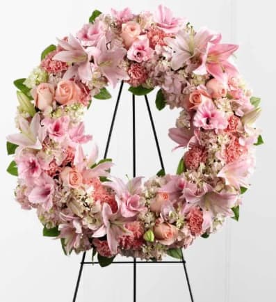 Loving Remembrance Wreath - Loving Remembrance Wreath is a blushing display of grace and beauty to honor the life of the deceased at their final tribute. Pink roses, Oriental lilies, gladiolus, hydrangea and carnations are brought together with lush greens to form the shape of a wreath, offering warmth and comfort with its sweetly sophisticated elegance. Displayed on a wire easel.
