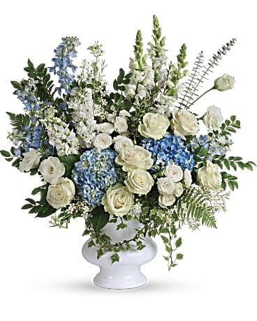 Treasured and Beloved Bouquet Treasured and Beloved Bouquet - Honor the memory of your beloved with this breathtaking bouquet of sky blue hydrangea and cloud white roses in a classic white urn. •This beautiful bouquet of light blue hydrangea, white roses, white spray roses, white lisianthus, light blue delphinium, white snapdragons, white stock, and white waxflower is accented with huckleberry, variegated ivy, spiral eucalyptus, dagger fern, and lemon leaf. •Delivered in a white designer urn. •Orientation: One-Sided