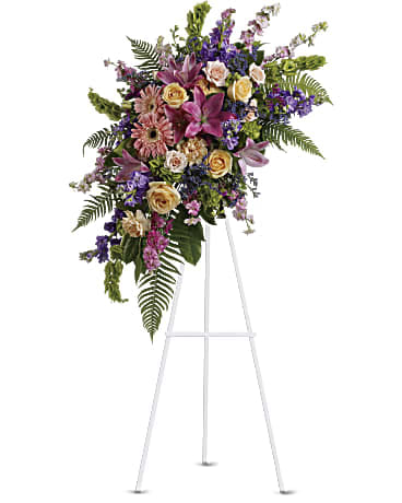 Heavenly Grace Spray - Share your feelings with this bountiful, cascading standing spray of feminine sympathy flowers. Peach roses and pink lilies pair perfectly with tropical greenery.   •Includes lovely flowers such as roses, carnations, gerberas, asiatic lilies and larkspur, plus green fern and bells of Ireland. •Orientation: One-Sided 