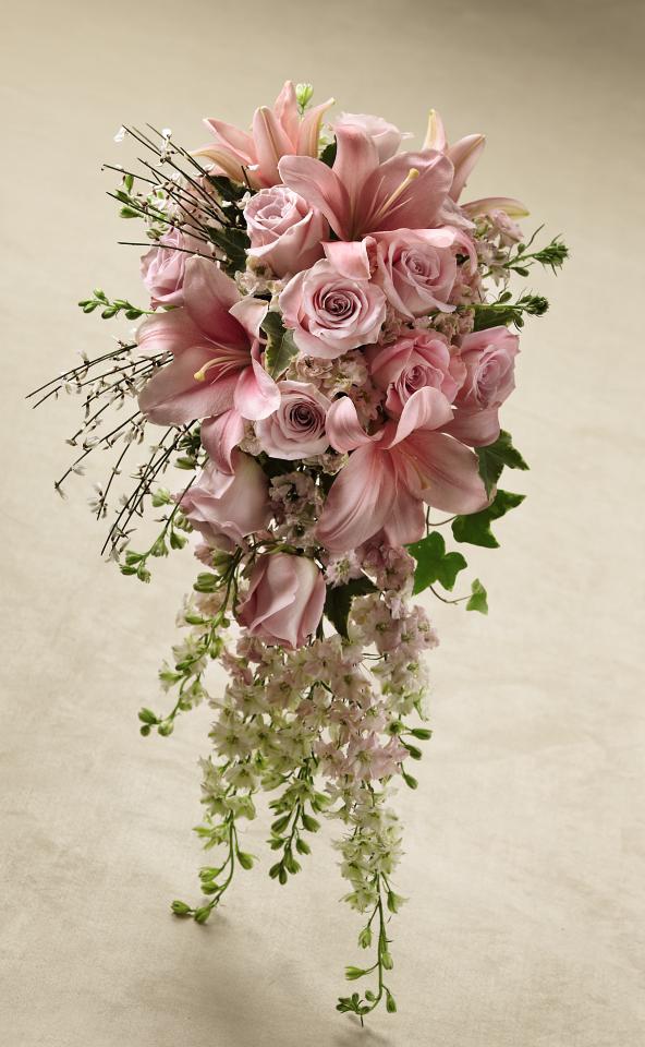 Pink liliy and rose bouquet Pink liliy and rose bouquet - This bouquet is a gorgeous statement piece to create the ultimate bridal look. Pink roses, larkspur, and LA Hybrid Lilies are blushingly beautiful accented with white genista and variegated ivy. Tied together at the stems with a silver gray satin ribbon, this bouquet brings a sweet sophistication to your big day. Approx. 24âH x 14âW.