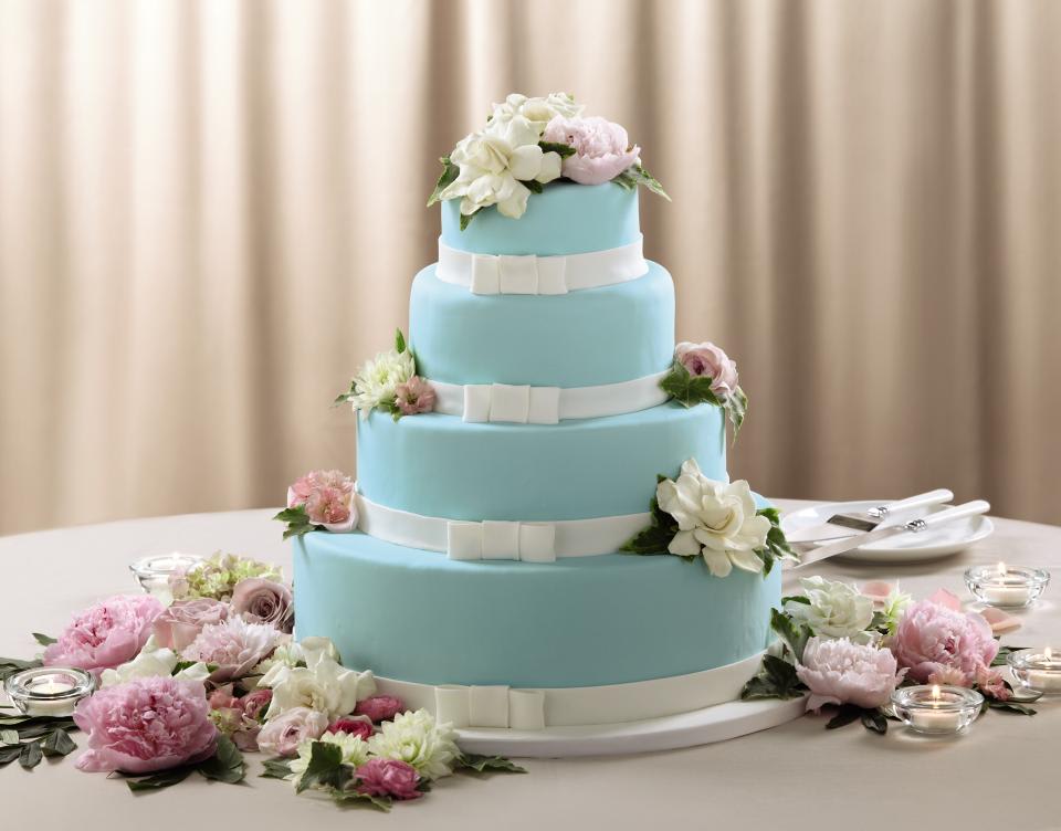 Cake Flowers Cake Flowers - These small cake décor features accents of white dahlias, pink ranunculus, pink peonies, white gardenias, pale pink roses, pink larkspur, pale pink hydrangea and variegated ivy to be set upon your cake for an exception look. Highlighted by 4 votive candles, this cake decor will add that extra special touch to your celebration. Approx. 18âH x 16âW.