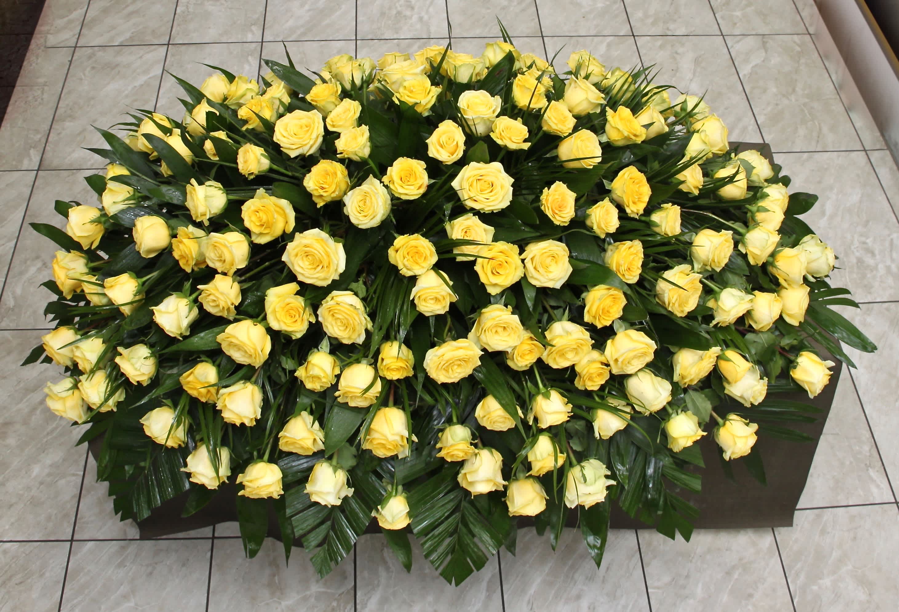 Yellow Rose Casket - This casket arrangement contains bright yellow roses and seasonal greens.     Standard size is half casket, deluxe is 3/4 and premium is full casket.