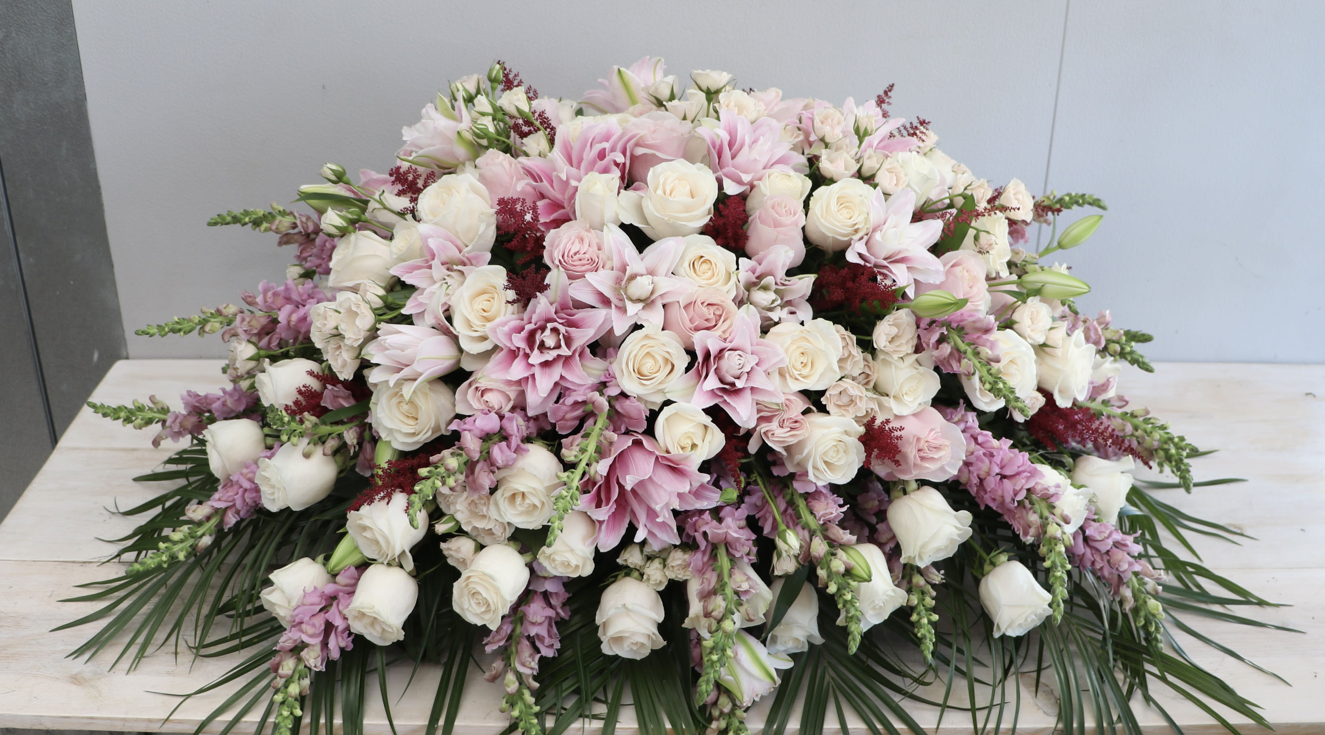 Pink Lily Casket Spray Pink Lily Casket Spray - This casket spray is made with pink lilies and a variety of pink roses and snapdragons. Standard size is half casket, deluxe is 3/4 and premium is full casket.