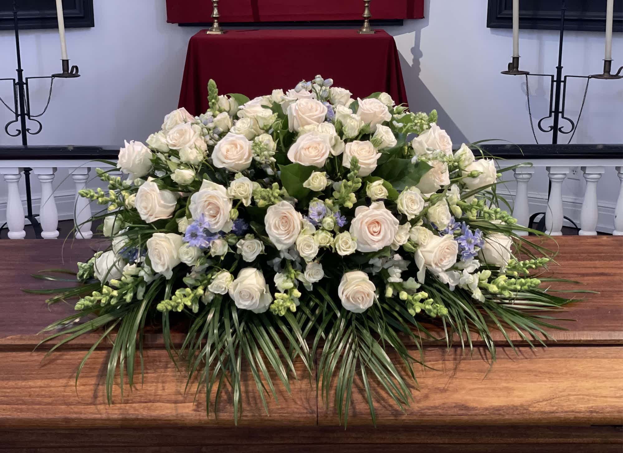 Tranquil Tribute Casket Spray Tranquil Tribute Casket Spray - This casket spray consists of mainly white florals with a delicate touch of blue. Standard size is half casket, deluxe is 3/4 and premium is full casket.