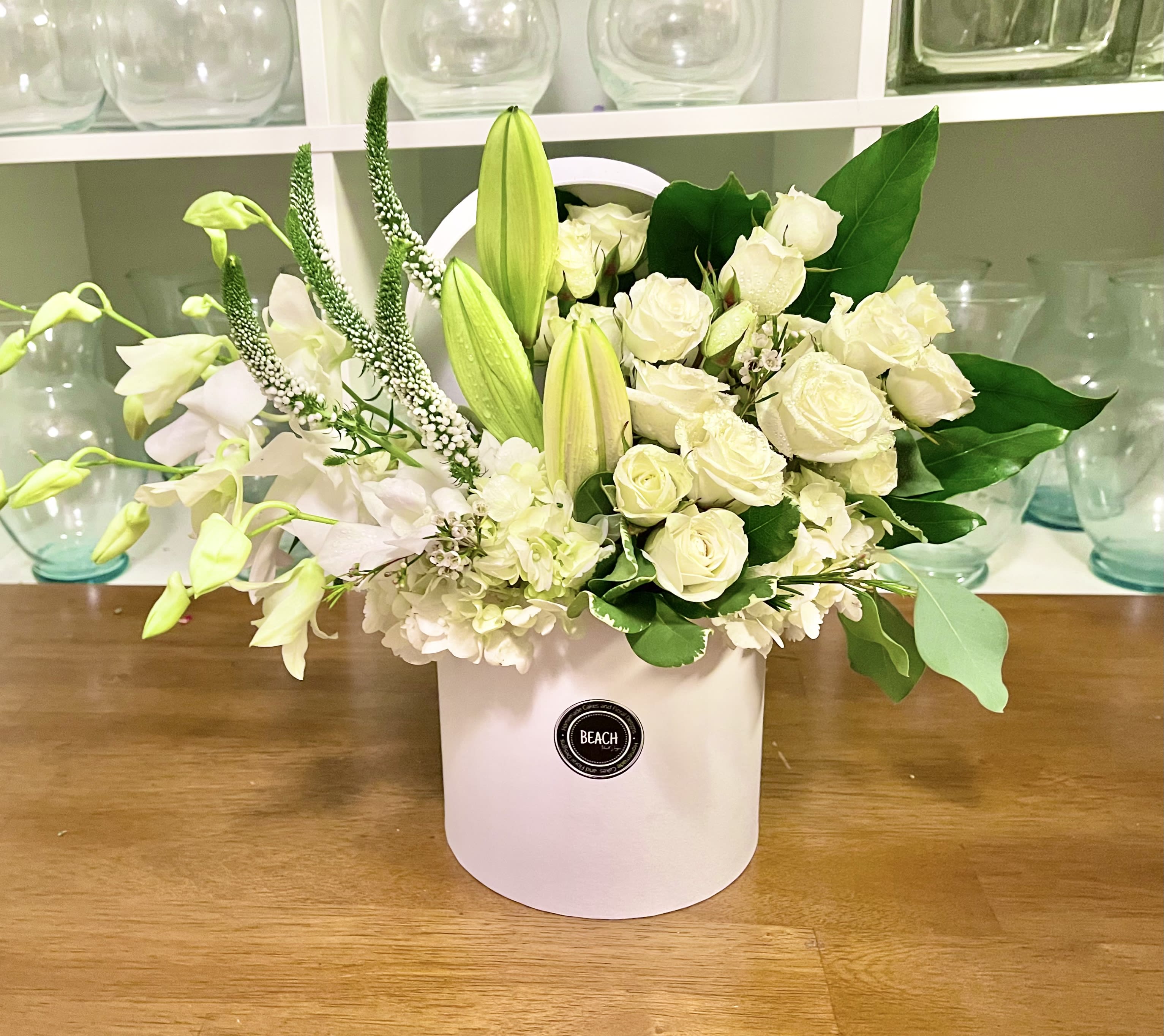 Frosted Frosted - Beautiful arrangement with lilies, mini roses, orchids and other fresh flowers in a trendy hat box.
