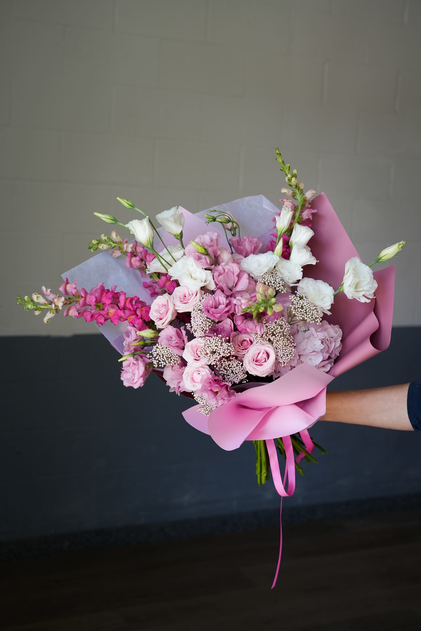 Rosy Delight Bouquet - Experience the timeless beauty of our Blushing Beauty Bouquet, a sophisticated arrangement of pink and white blooms that exude grace and charm. This stunning bouquet features a blend of pink roses, lisianthus, and snapdragons, complemented by delicate white flowers, all beautifully wrapped in luxurious pink paper. Perfect for any occasion, the Blushing Beauty Bouquet is a refined choice that adds a touch of elegance and warmth. Whether celebrating a special event or expressing your love and appreciation, this bouquet is a beautiful way to convey your heartfelt sentiments.