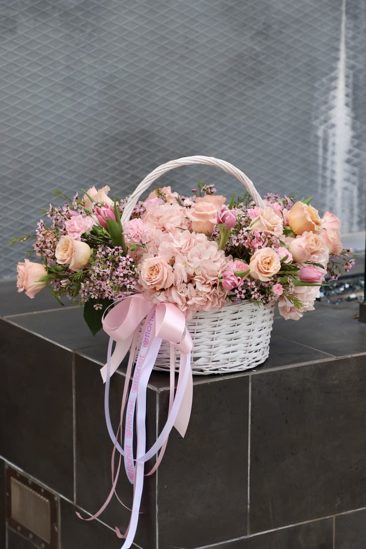 Basket Elegance Basket Elegance - The basket with pink flowers is a charming and delicate creation that exudes a sense of grace and femininity. The basket is crafted from natural materials, such as woven wicker or rattan, and is typically adorned with an assortment of pink flowers that may include roses, carnations, peonies, or other blossoms. The combination of the soft pink hue of the flowers and the rustic texture of the basket creates a beautiful contrast that is both soothing and uplifting to the senses. Whether used as a gift for a loved one or as a decorative accent for a home or event, a basket with pink flowers is a lovely and timeless addition to any space.