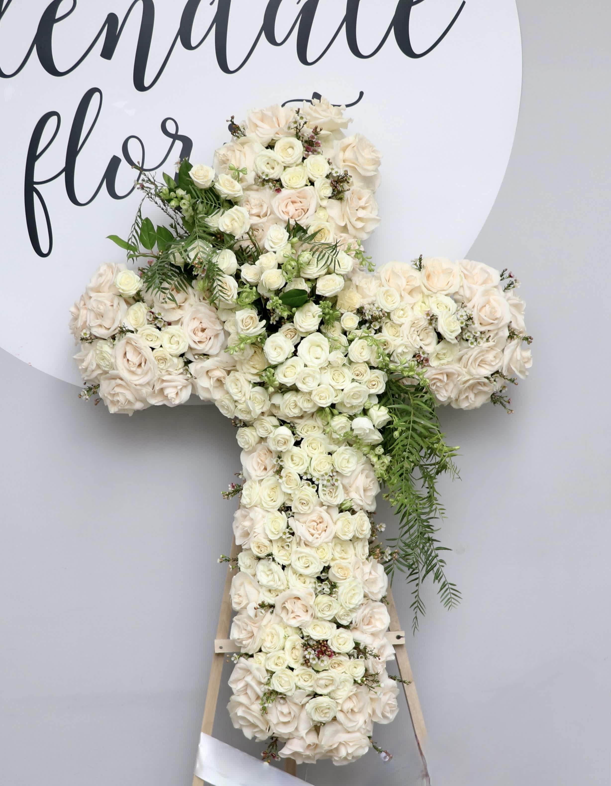 Forever Cross - White Cross filled with roses, spray roses and pop of green accents.    We include easel, printed banner and delivery (some fees may apply). An additional banner can be added for $15.    Standard size is 30'', deluxe is 36'', and premium is 42''.