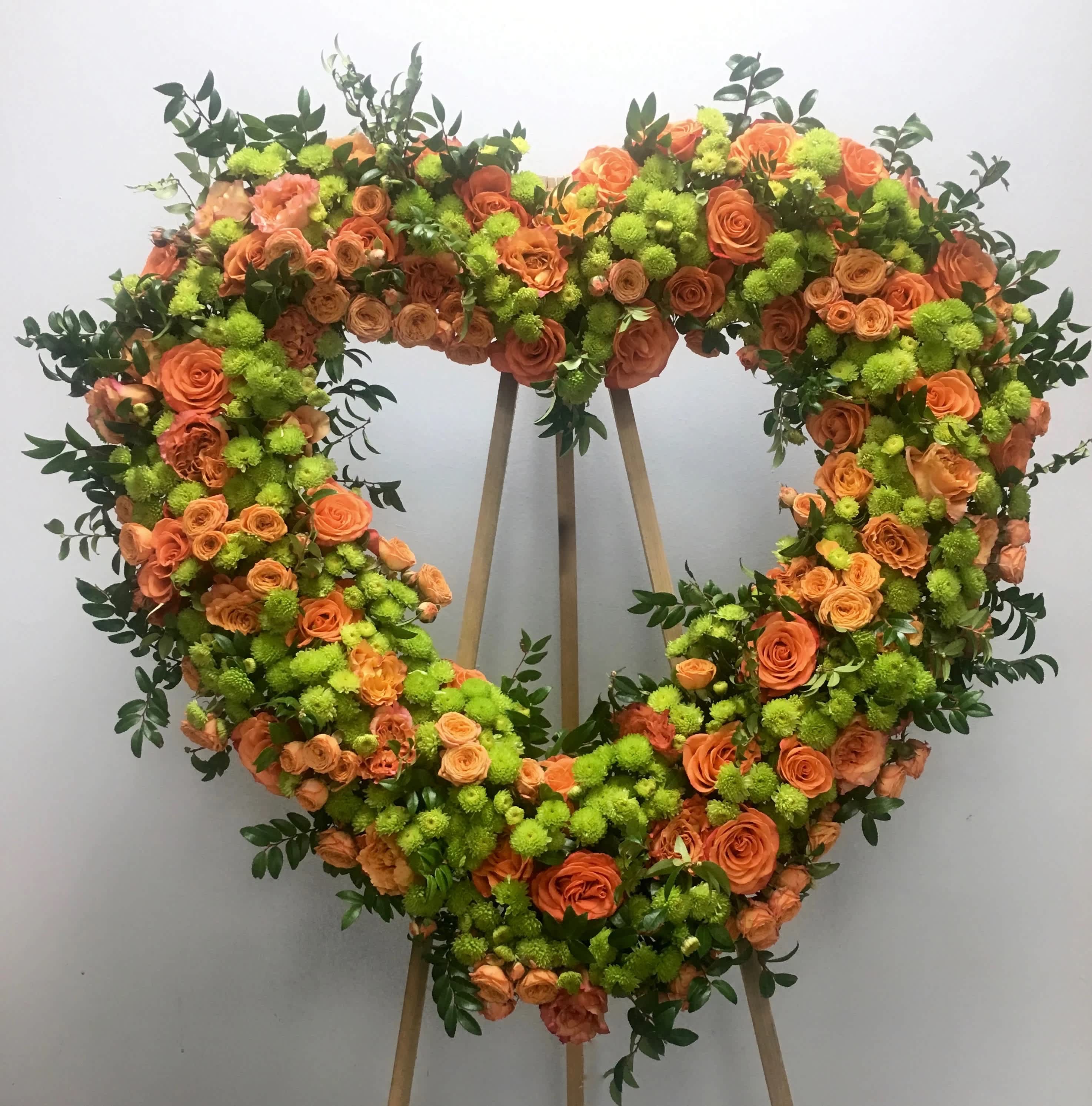 Orange Blossom Heart - &quot;This heart mixes an array of orange roses and seasonal greens to create a unique and vibrant memorial for a loved one.     We include easel, printed banner and delivery (some fees may apply). An additional banner can be added for $15    Standard size is 30'', deluxe is 36'', and premium is 42''.