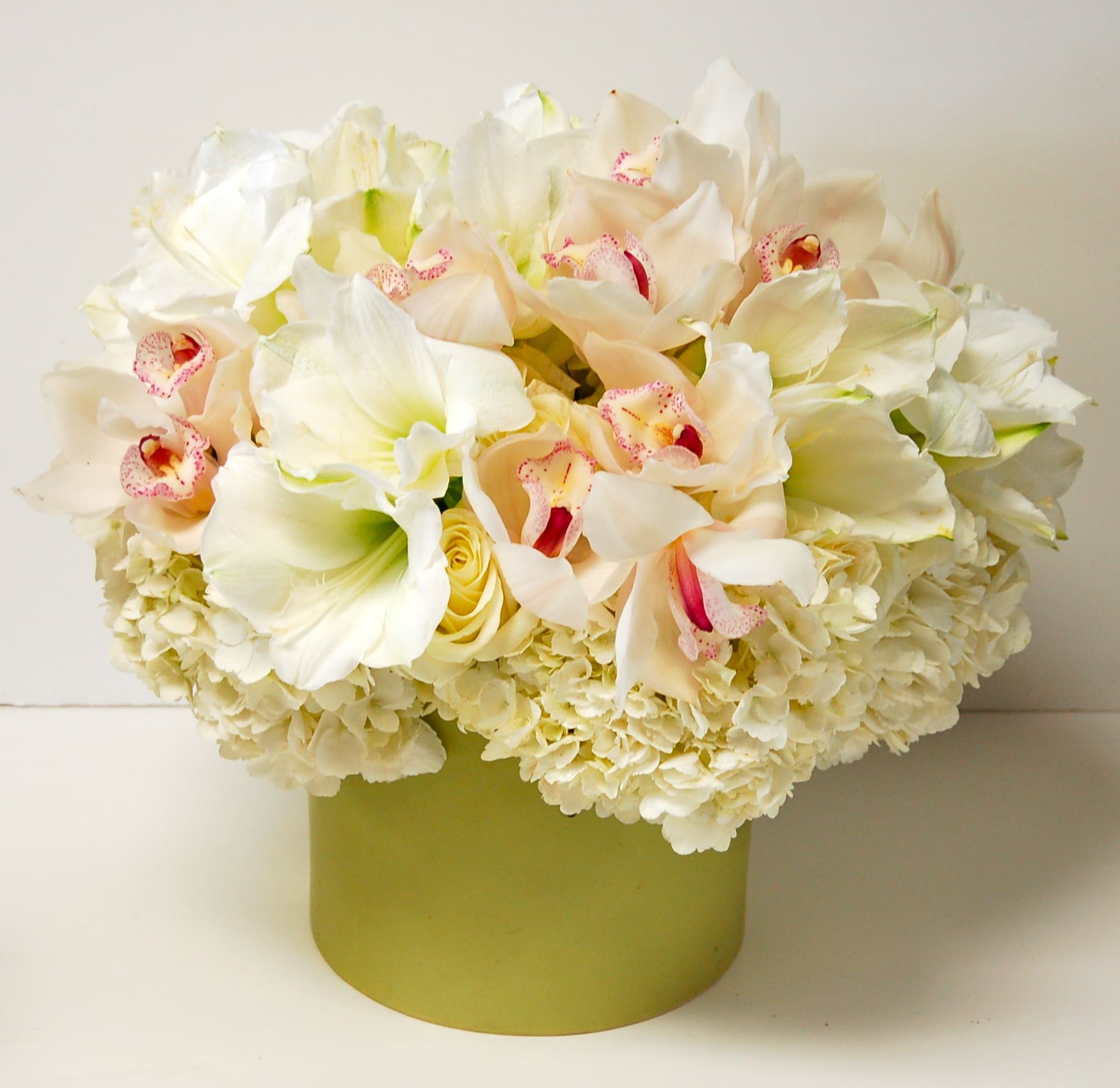 Beauty for Ashes - All White Seasonal Flowers: roses, hydrangeas, orchids and other seasonal flowers and greens in a ceramic container.  *Standard size is approximately 14&quot; x 14&quot;.