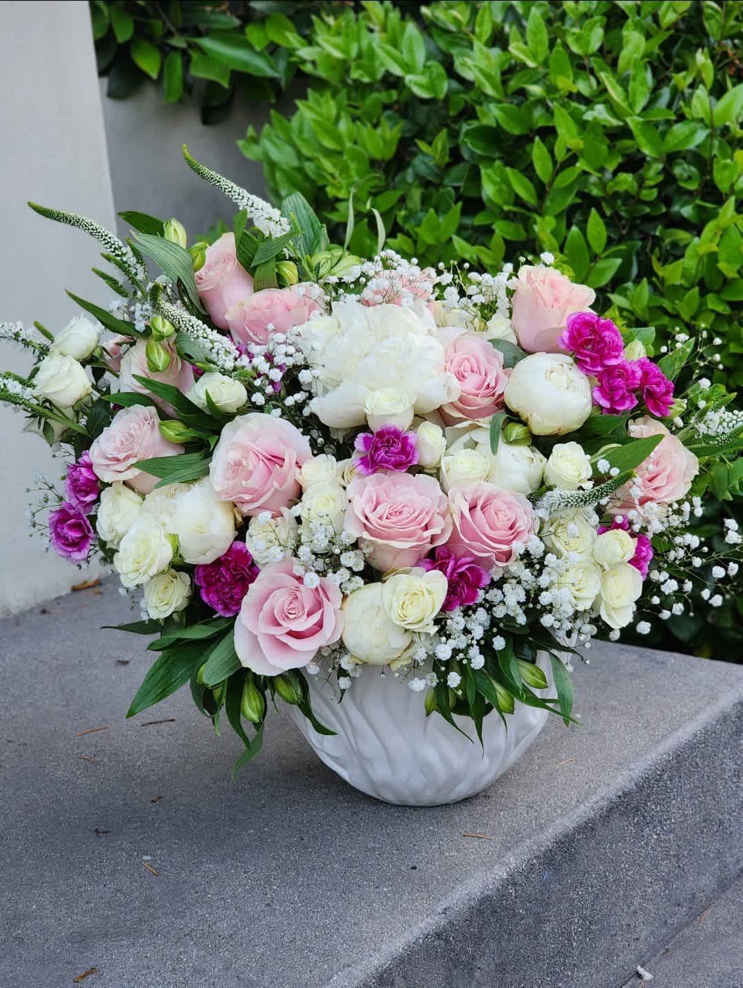 Here and Now - A stunning white vase arrangement featuring elegant peonies,pink roses, white spray roses, pink-white mix flowers. Perfect for any occasion, this arrangement exudes beauty and simplicity. Ideal for weddings, anniversaries, or home decor
