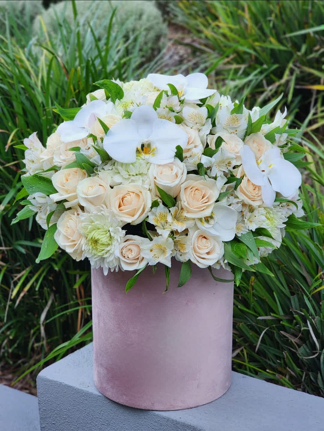 Hello Beautiful - A charming and beautiful flowers.  Featuring ivory roses, an assortment of mixed flowers, elegant orchids presented in a pink hatbox.  Disclaimer: ALL IMAGES PROVIDED AT DELUXE PRICE 