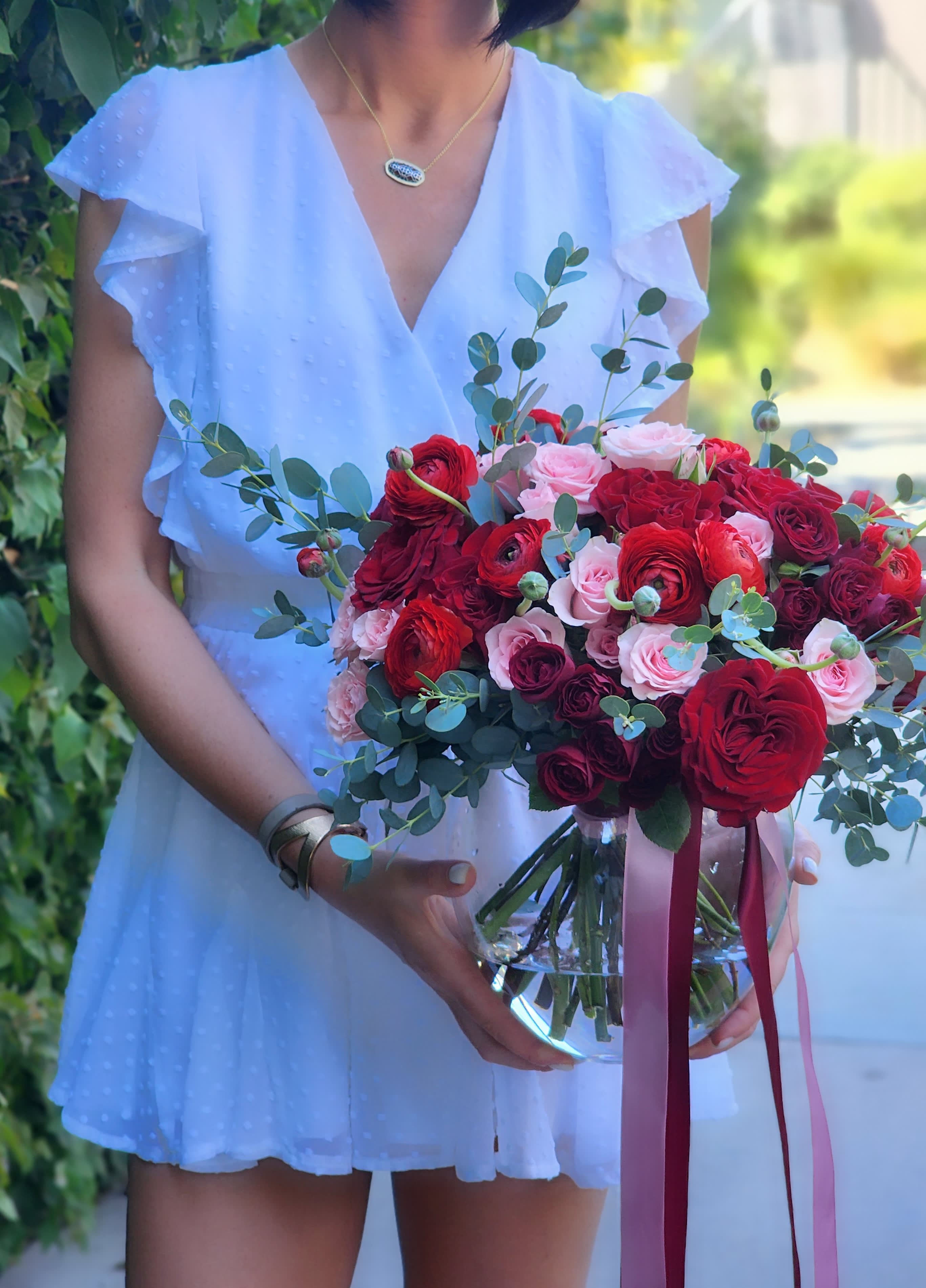 Love's Fiery - Discover stunning arrangements with red roses, vibrant ranunculus, pink spray roses, and fresh green eucalyptus. Perfect for any occasion! 
