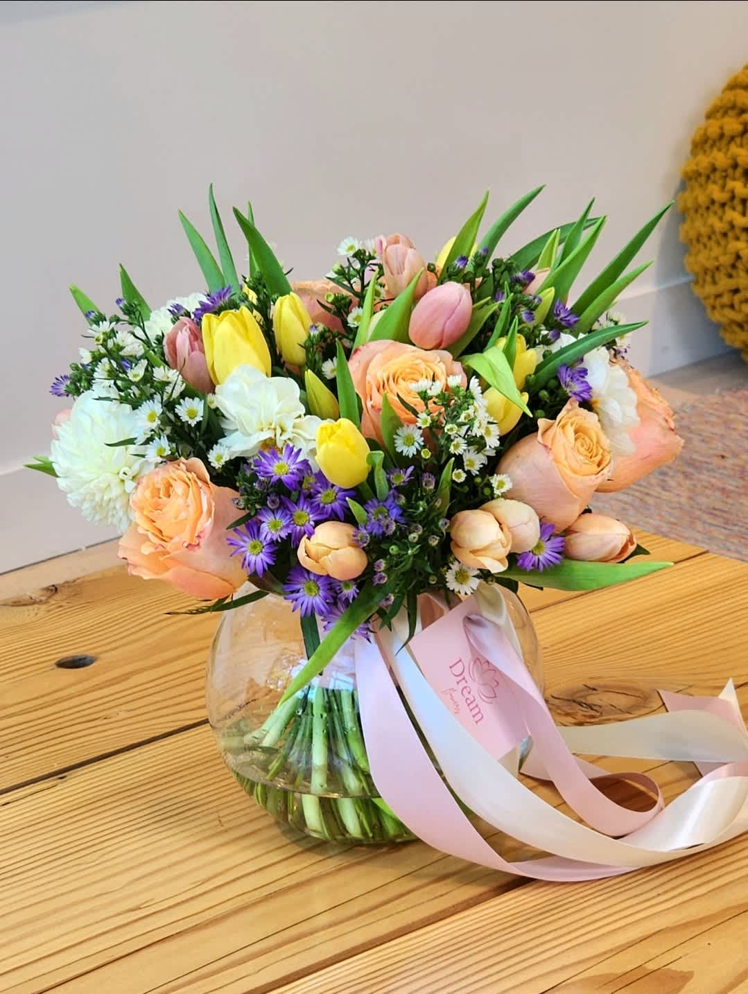Summer Morning  -  A clear vase arrangement featuring peach roses, yellow tulips, white dahlias, and mix flowers. Summer floral display is perfect for any occasion. Fresh, stunning, and stylishly simple.