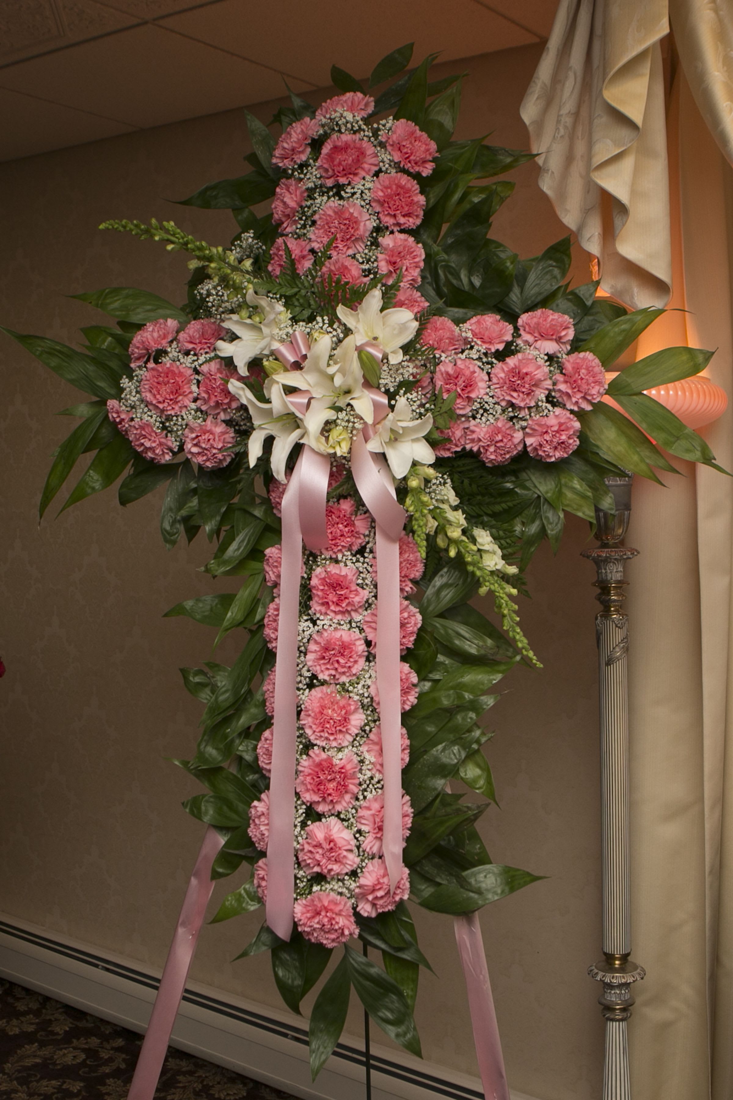 Pink Carnation Cross Pink Carnation Cross - Show your support and sympathy by sending this beautiful cross of carnations. The cross can be created in various colors and will include carnations with baby's breath and mixed garden flowers. Approximately 36" length x 24" wide. Stands on 6/5 foot easel. Please order by 10am for delivery for a 2pm showing. As Shown : BF-Cross1