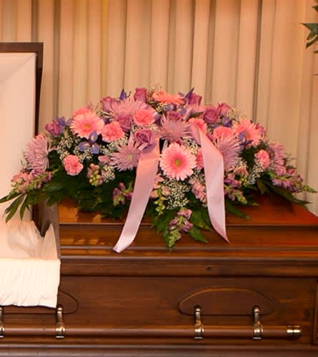 Pink and Lavender Casket Cover - Honor her femininity and generous spirit with a blanket of sweetly scented lavender, pink and purple flowers that create a magnificent final tribute, sincerely expressing devotion and love. Gorgeous pink and lavender flowers such as roses, snapdragons, alstroemeria, hydrangeas, chrysanthemums, gerberas, etc..  Bassett Flowers may substitute flowers to ensure quality of arrangement.  As Shown : BF-CC4
