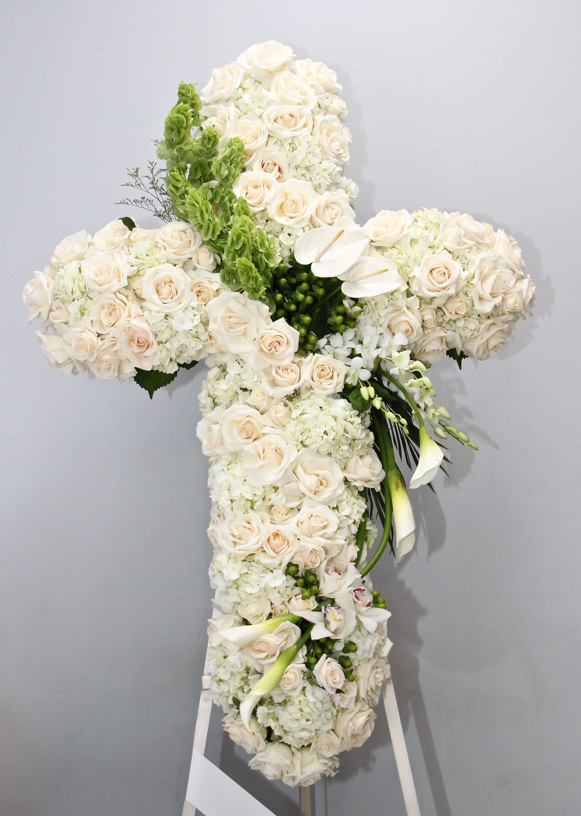 Heavenly Cross  - This beautiful sympathy cross includes fluffy hydrangeas, roses, lilies and seasonal greens.       We include easel, printed banner and delivery (some fees may apply). An additional banner can be added for $15.    Standard size is 30'', deluxe is 36'', and premium is 42''.