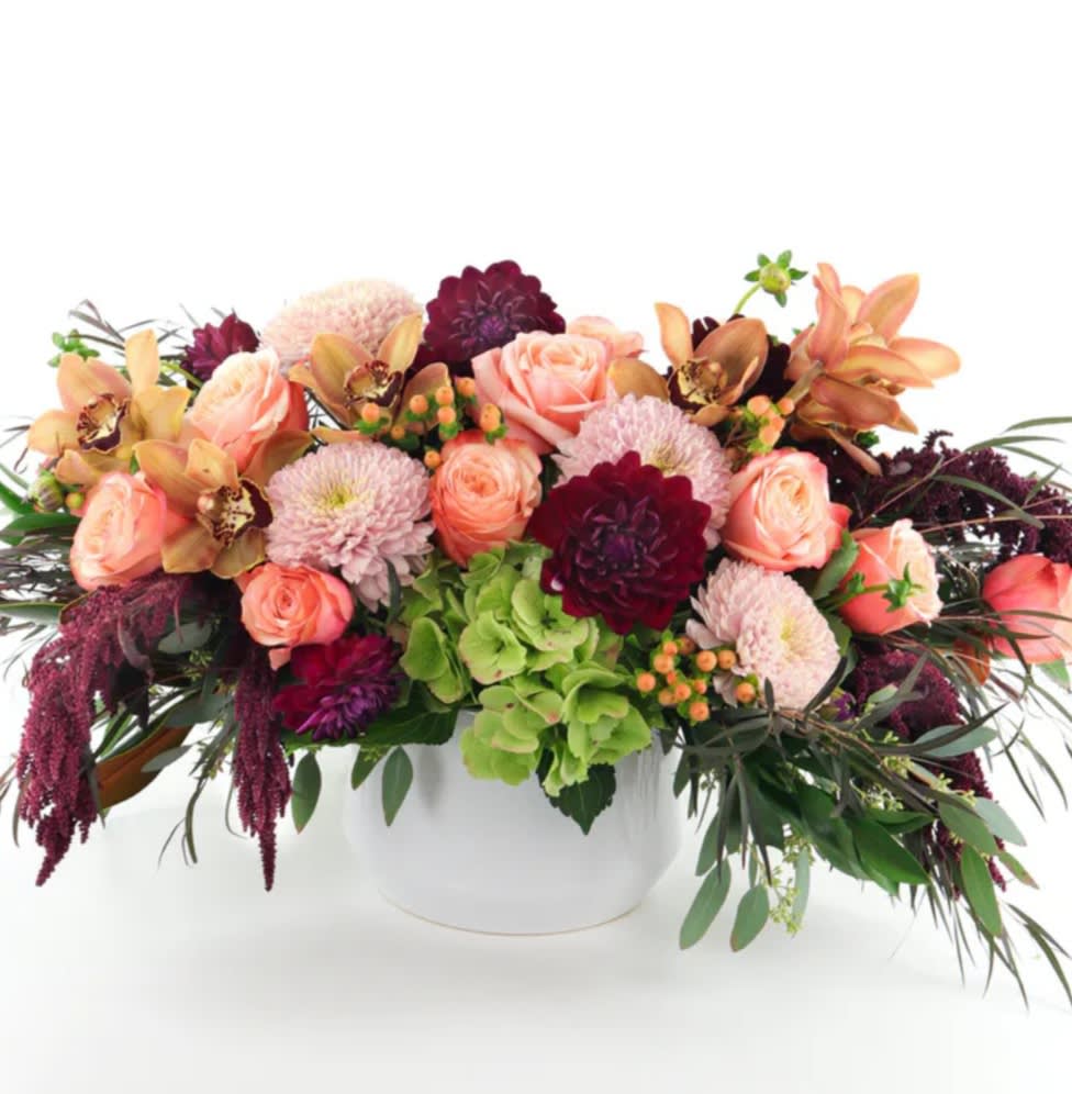  A Premium Centerpiece in a white ceramic - A Designer's Choice seasonal mix in a long and low style designed in a white ceramic container. Flowers may vary but always made with premium flowers. 