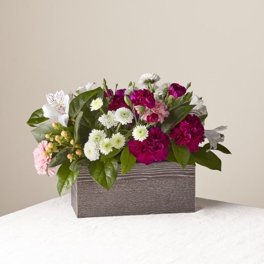 FRESH FIELDS BOUQUET - Designed with the freshest blooms of peach roses, purple carnations, pink carnations, white button mums, white alstroemeria and peach hypericum berries displayed in rectangle wooden box, this arrangement captures both the look of a refined bouquet and the unique beauty of wildflowers. 
