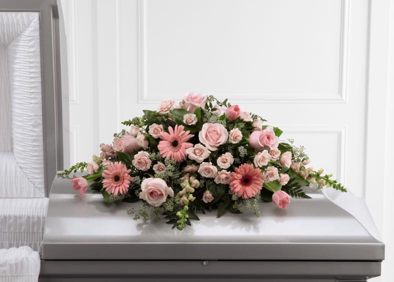 FTD Sweet Farewell Casket Spray - The FTD Sweet Farewell Casket Spray exudes an atmosphere of grace  and soft serenity to commemorate a life lived with warmth and caring  kindness. Blushing pink roses, gerbera daisies, spray roses, tulips and  snapdragons are offset by a variety of lush greens and lovingly arranged  to create a stunning accent piece intended to adorn the top of their  casket at their memorial service.    10h x 36w  S24-4490