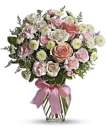 Cotton Candy - Sweet as candy! This soft pink and white bouquet is a feminine choice for any occasion. A mix of pink and white flowers including roses, miniature carnations and button spray chrysanthemums is delivered in a spring garden vase adorned with pink ribbon. Orientation: All-Around