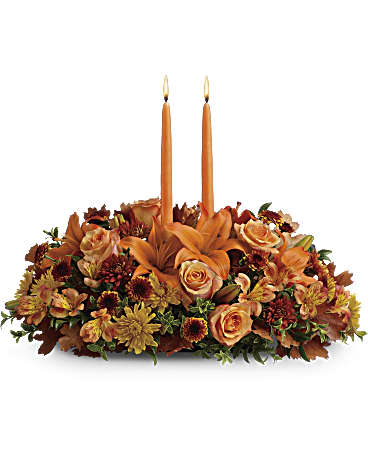 Family Gathering Centerpiece - Graciously gather your family around the warm glow and classic autumn colors of this stunning Thanksgiving centerpiece. A lush variety of burnt orange blooms are gathered under a pair of tall, graceful candles - perfect for decorating your Thanksgiving dinner table, entryway or hearth. Fall flowers include orange roses, orange asiatic lilies, dark orange alstroemeria, bronze button mums, yellow cushion mums, rust cushion mums, green oregonia and green huckleberry. Accented with oak leaves and two orange taper candles. Orientation: All-Around