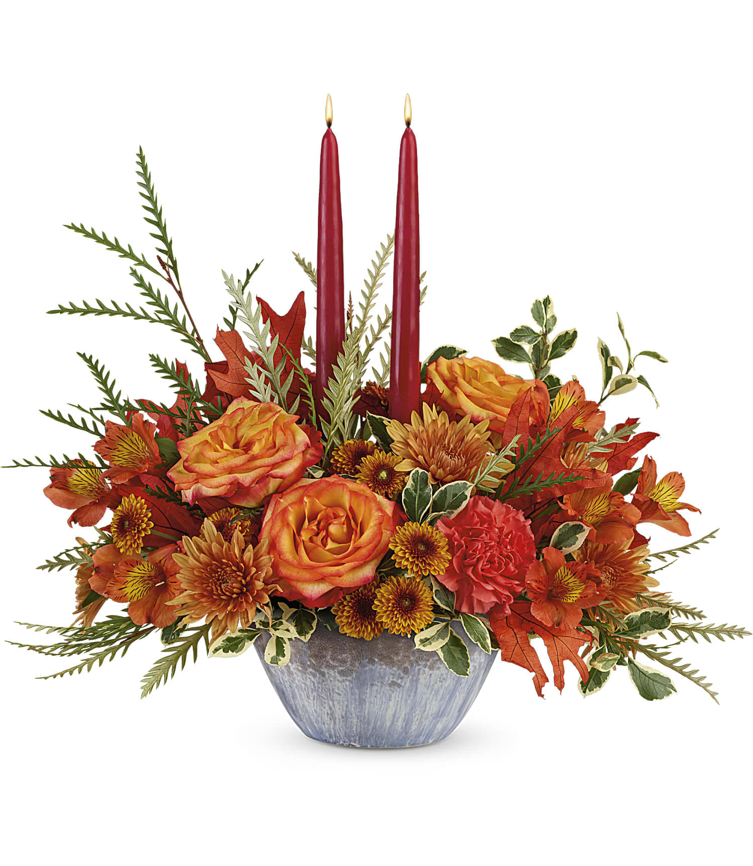 Teleflora's Bountiful Blessings Centerpiece Teleflora's Bountiful Blessings Centerpiece - A bounty of warm wishes for a happy fall! This lush autumnal rose centerpiece is arranged in a stunning, oven-to-table ceramic serving bowl with gorgeous artisanal glaze in steel blue hues--a gift they'll enjoy for many years to come! Orange bi-color roses, orange alstroemeria, orange carnations, orange button spray chrysanthemums and rust cushion spray chrysanthemums are accented with grevillea, oregonia, and two dark burgundy candles. Delivered in Teleflora's Bountiful Blessings Bowl. Approximately 17 1/2" W x 16" H