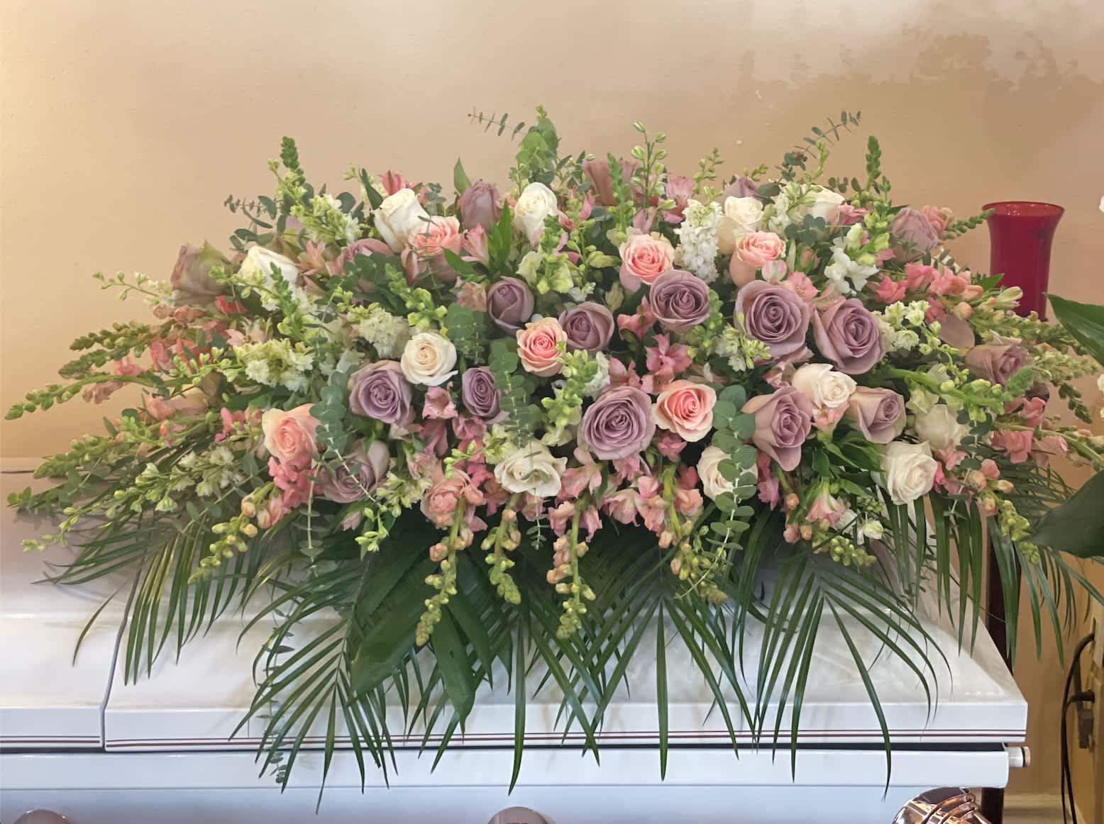 Amor Casket Amor Casket - Seasonal lavenders, pinks and greens flowers make up this casket arrangement. Standard size is half casket, deluxe is 3/4 and premium is full casket.