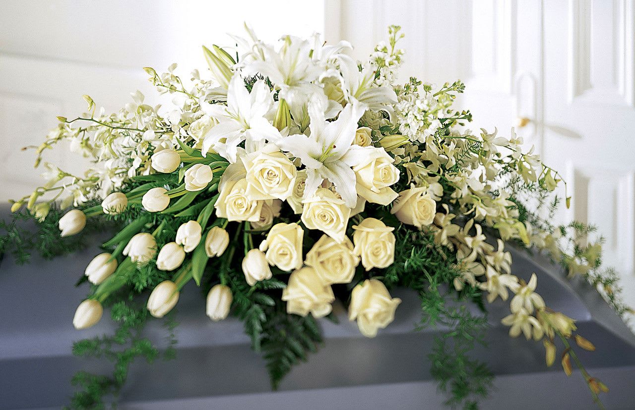 Grand All White Casket Spray Grand All White Casket Spray - Grand all white casket spray made with White Lilies, White Roses, White Orchids, White Stock, White Tulips*, and fillers. * Tulips replaced when not in season.