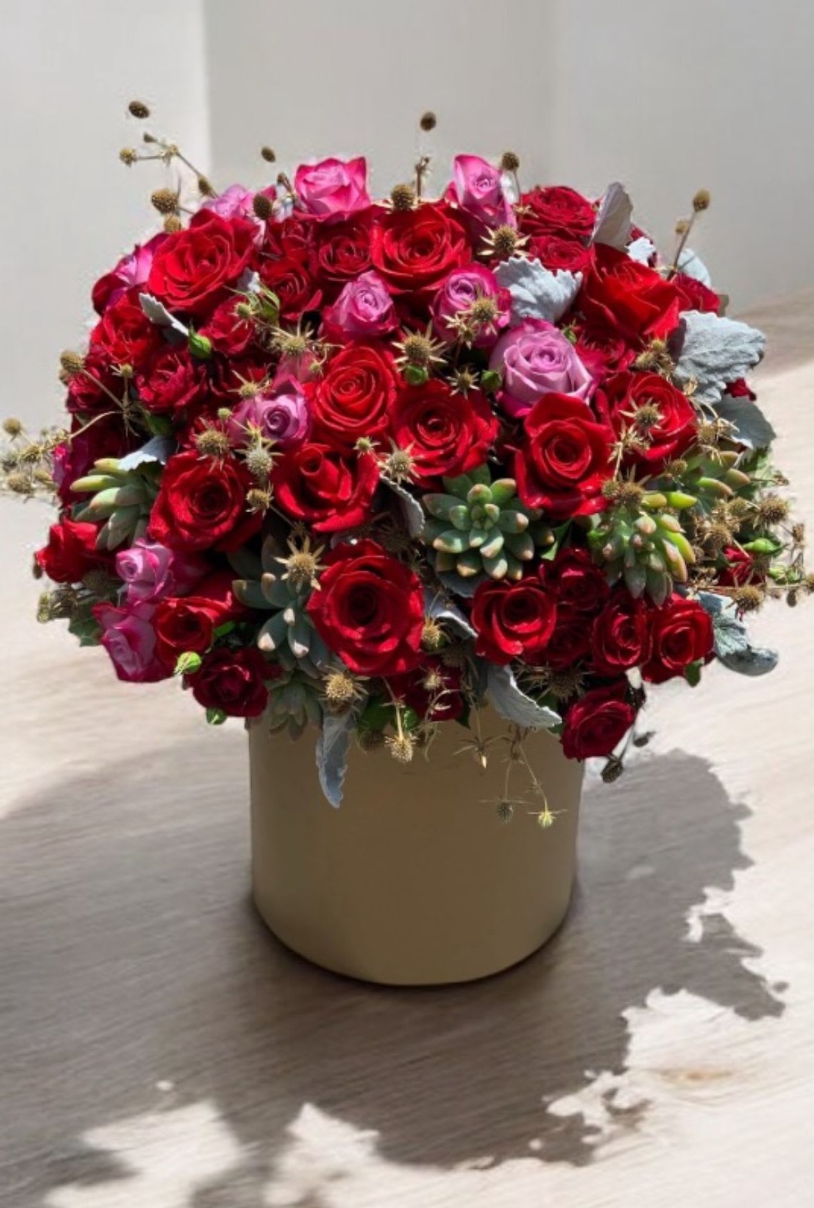 Red Rose Garden - Red roses, two toned pink and purple roses, green succulent, Eryngos, dusty miller, in a Large gold box. (also available in different sizes)