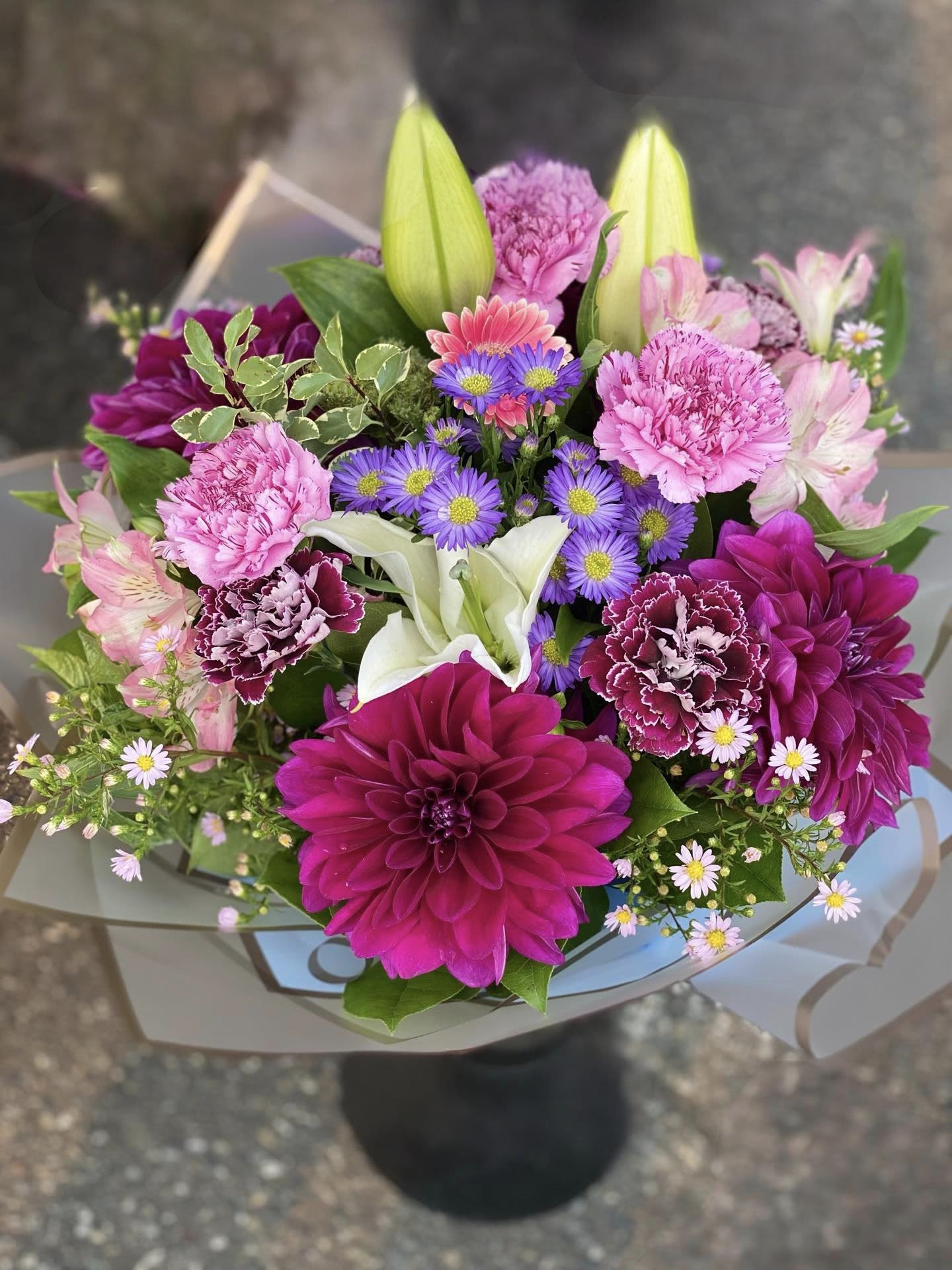 Mix Purple - An artistic and purple arrangement is a pleaser and interesting as it is impressive. Purple, pink and with a touch of White and blue is an architectural design give this arrangement its unique appeal. Wrap or Vase same price  APPROXIMATE DIMENSIONS       12&quot;W X 18&quot;H Standard                                                            14&quot;W X 22&quot;H Deluxe                                                           16&quot;W X 25&quot;H   Premium  