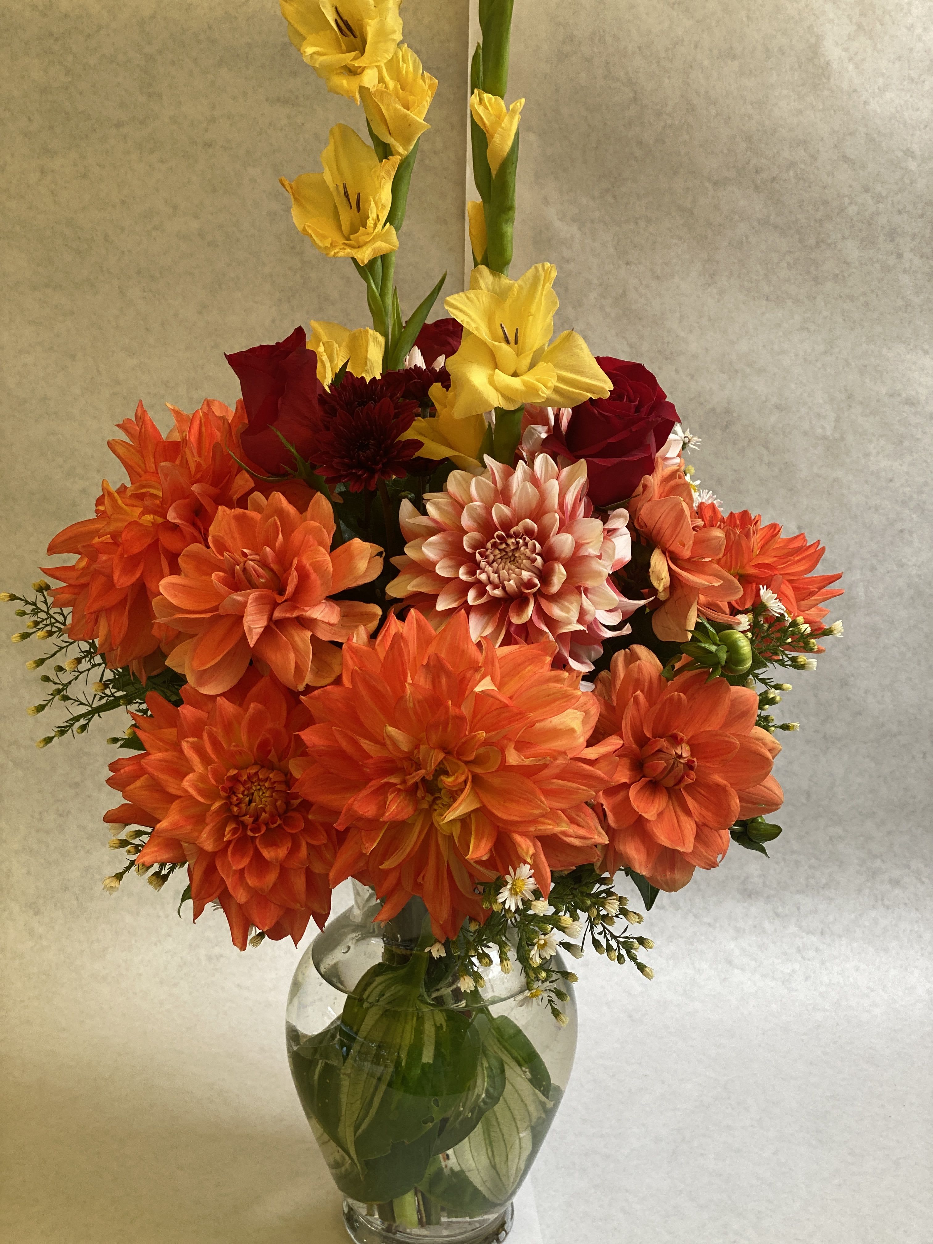 ready for fall - An artistic and bright fall color arrangement is a pleaser and interesting as it is impressive. Orange, yellow and red.   is an architectural design give this arrangement its unique appeal. Wrap or Vase same price  APPROXIMATE DIMENSIONS       12&quot;W X 18&quot;H Standard                                                            14&quot;W X 22&quot;H Deluxe                                                           16&quot;W X 25&quot;H   Premium  